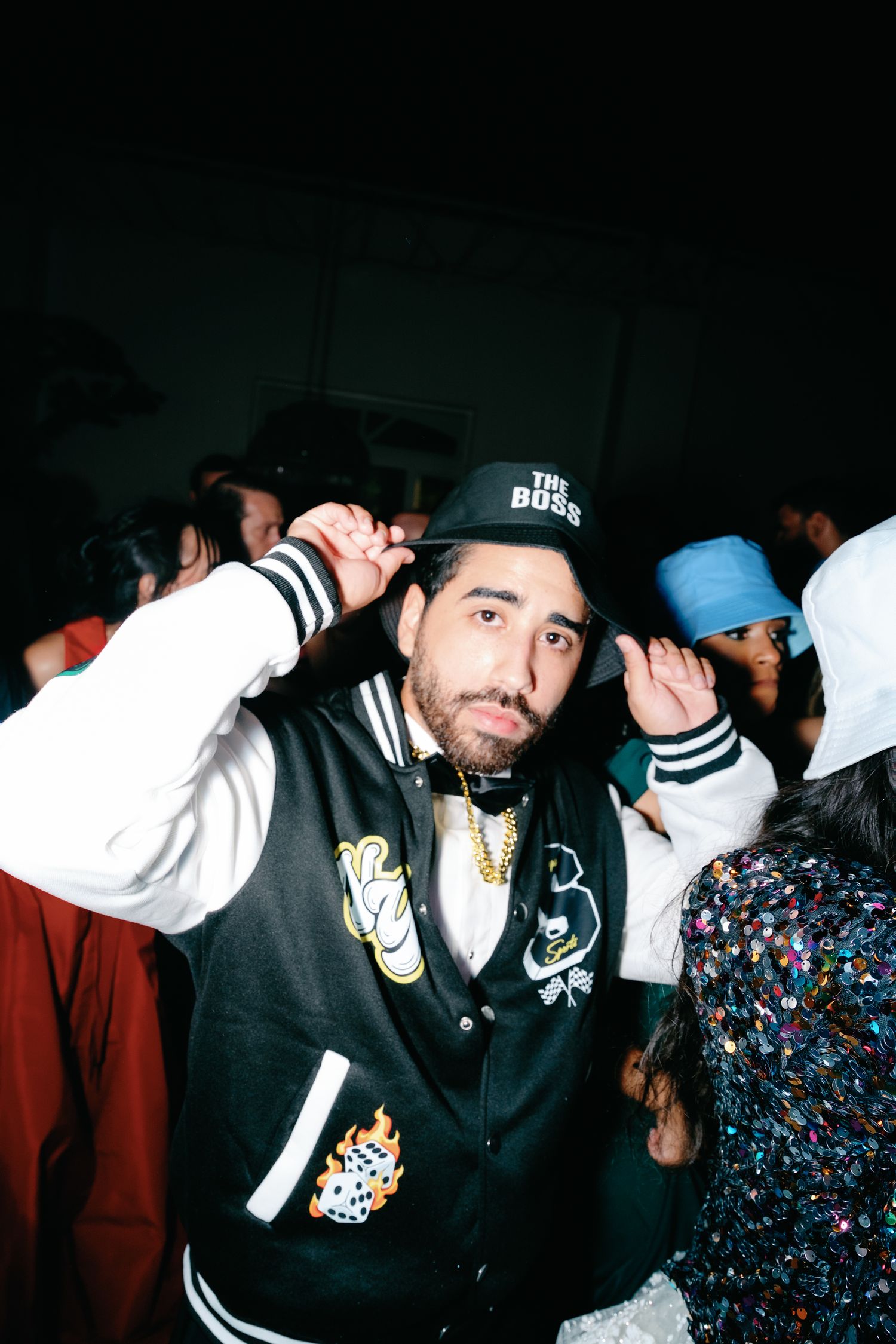Partygoers in black and white outfits dancing and socializing at a nightclub event.