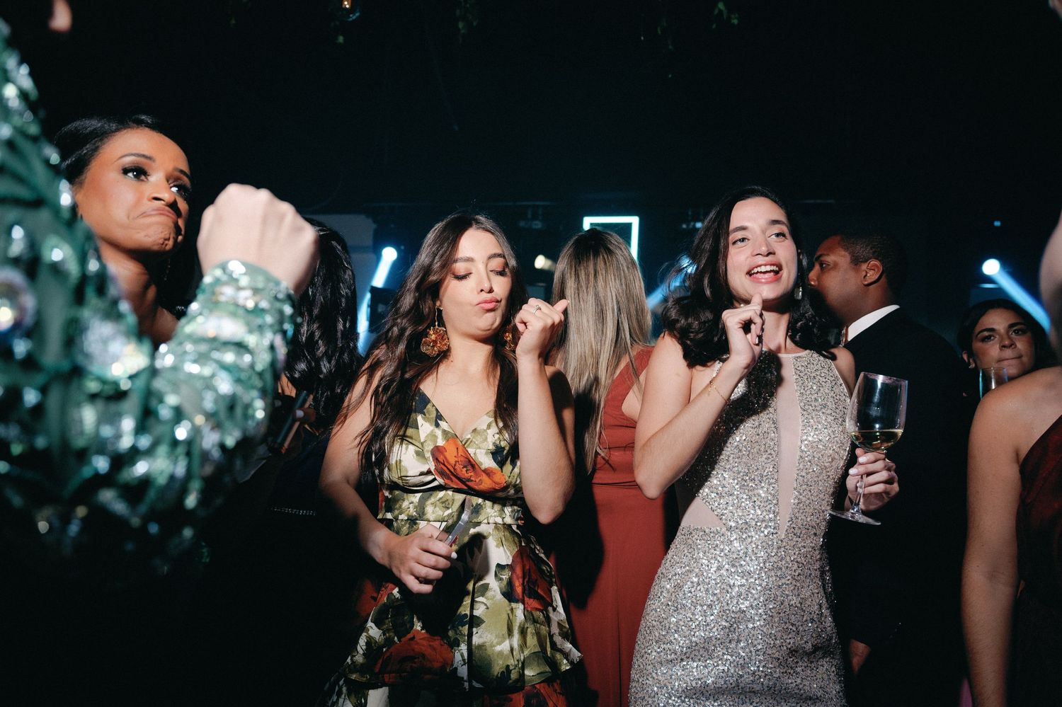 People dancing and celebrating at a lively nightclub party with colorful lighting and festive atmosphere.