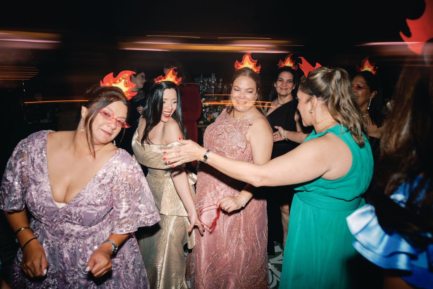 People enjoying themselves on a dance floor illuminated by colorful party lights.