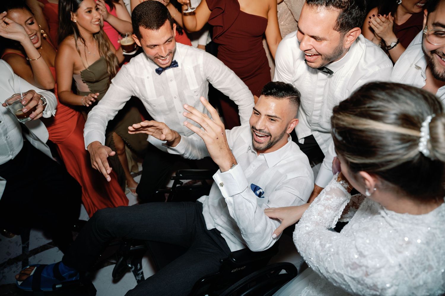 A group of people dancing and celebrating at a lively party in a dimly lit room.