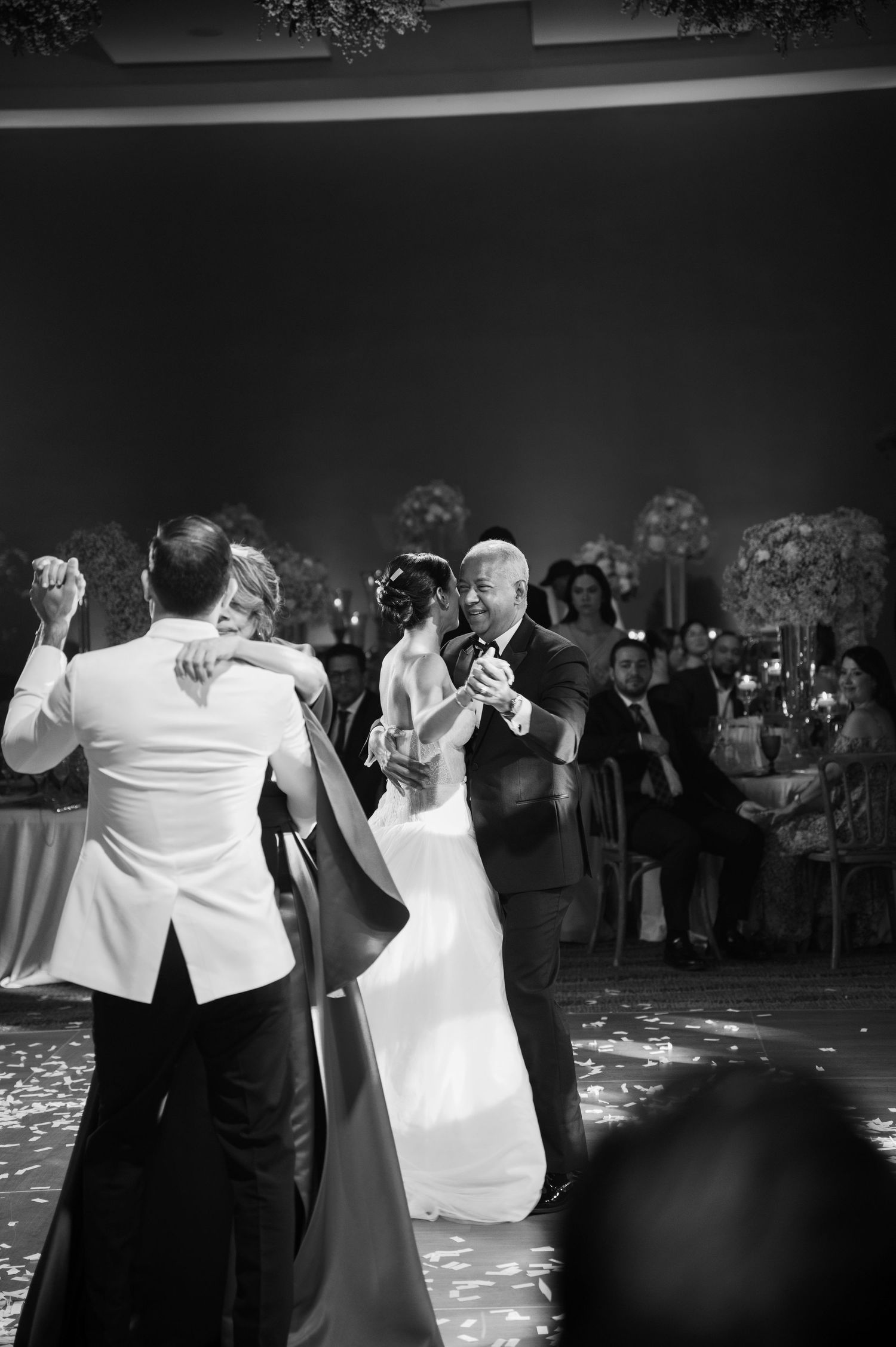 A sequence of black and white photos showing wedding guests dancing and celebrating at a reception.