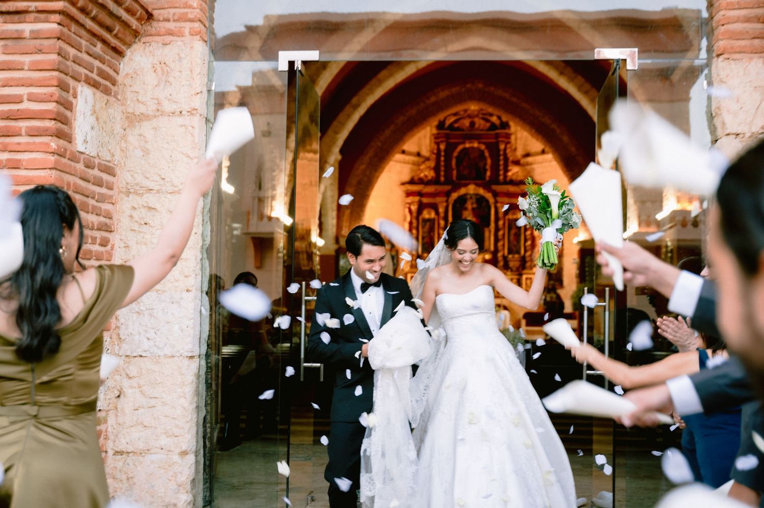 A bride and groom share a romantic dance moment under ornate brick archways at their wedding reception.