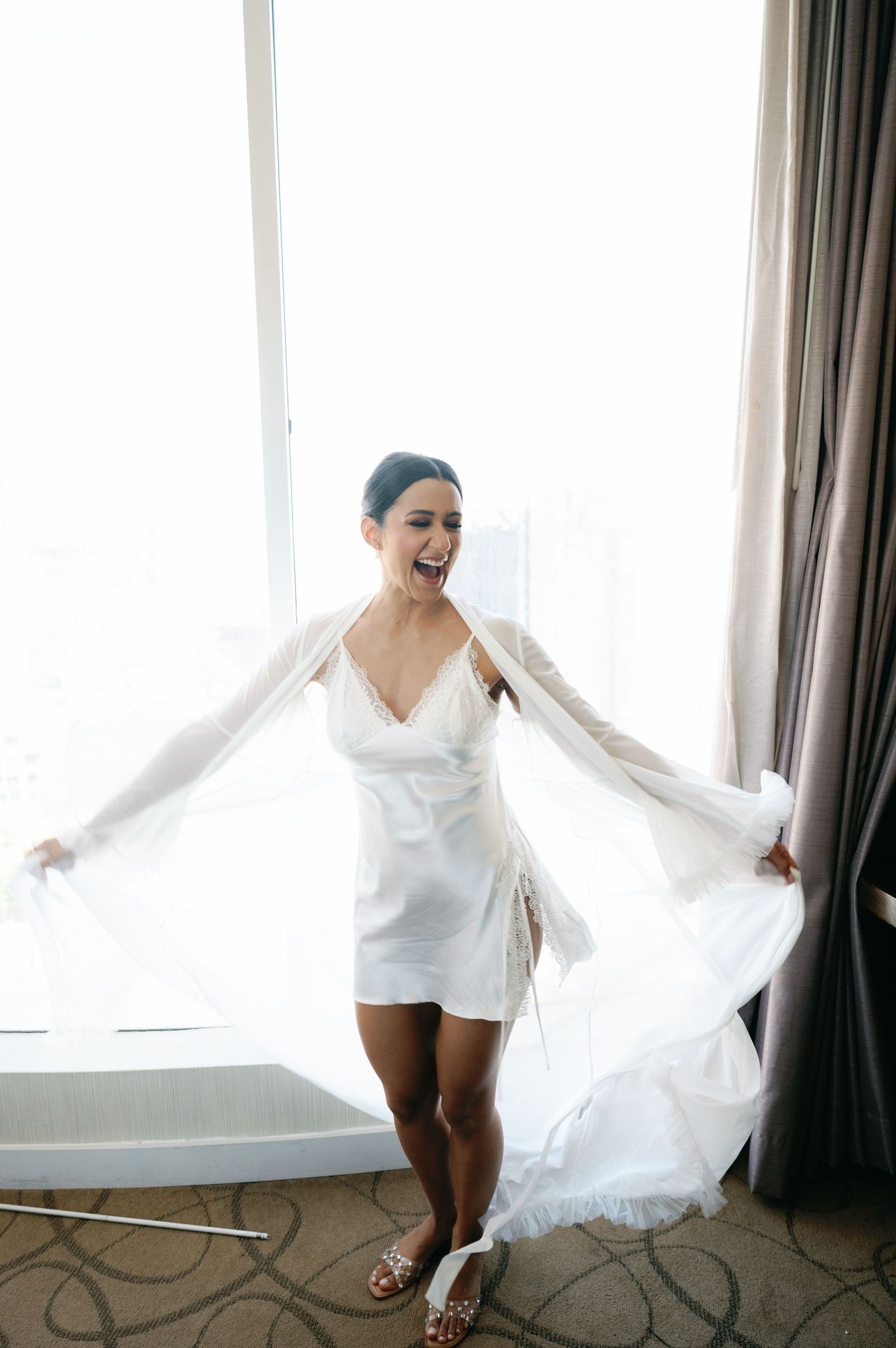 A sequence of four photos showing someone in a white dress twirling and dancing joyfully in front of curtained windows.