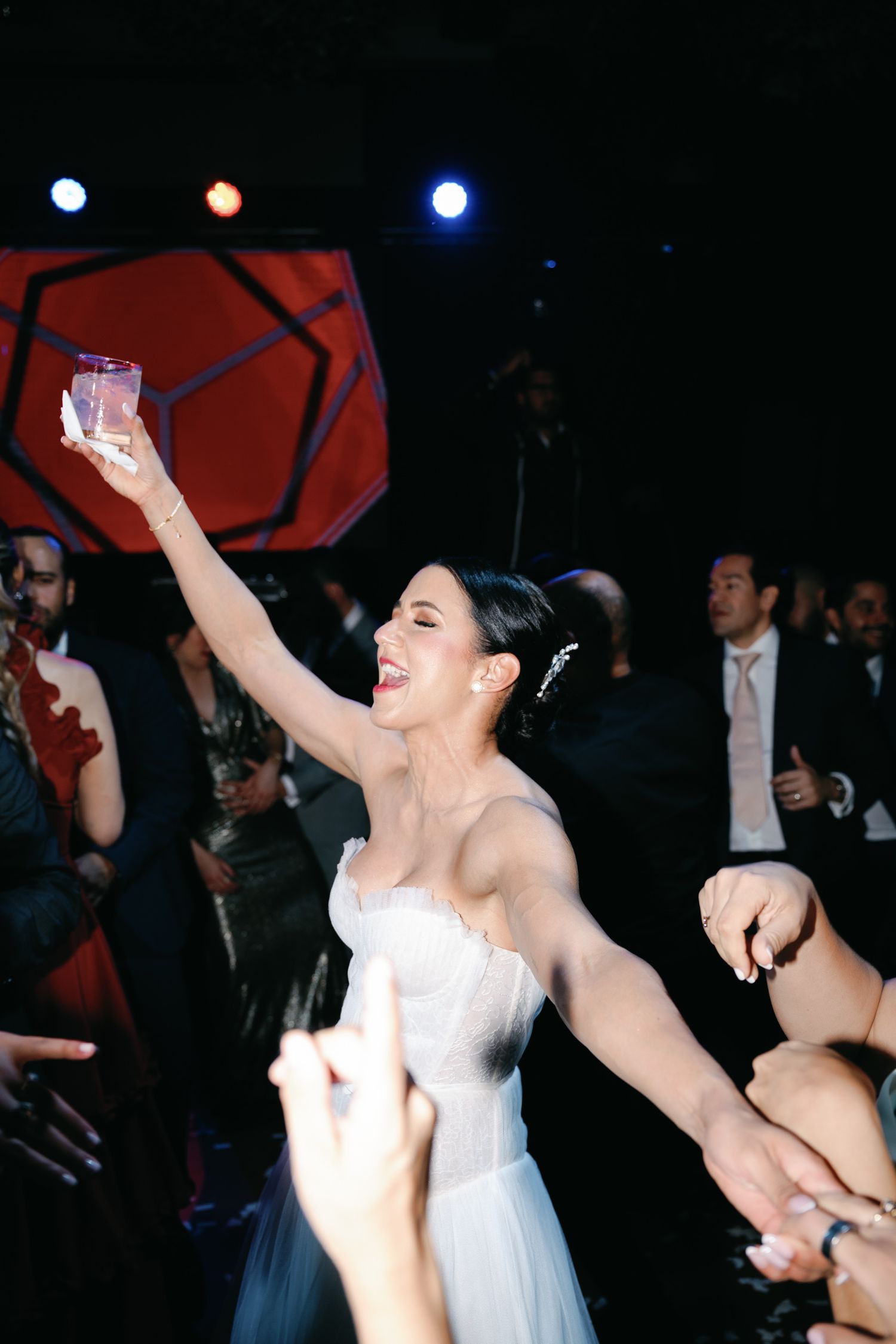 A series of celebratory moments at a wedding reception showing dancing and joyful expressions in a dark venue.