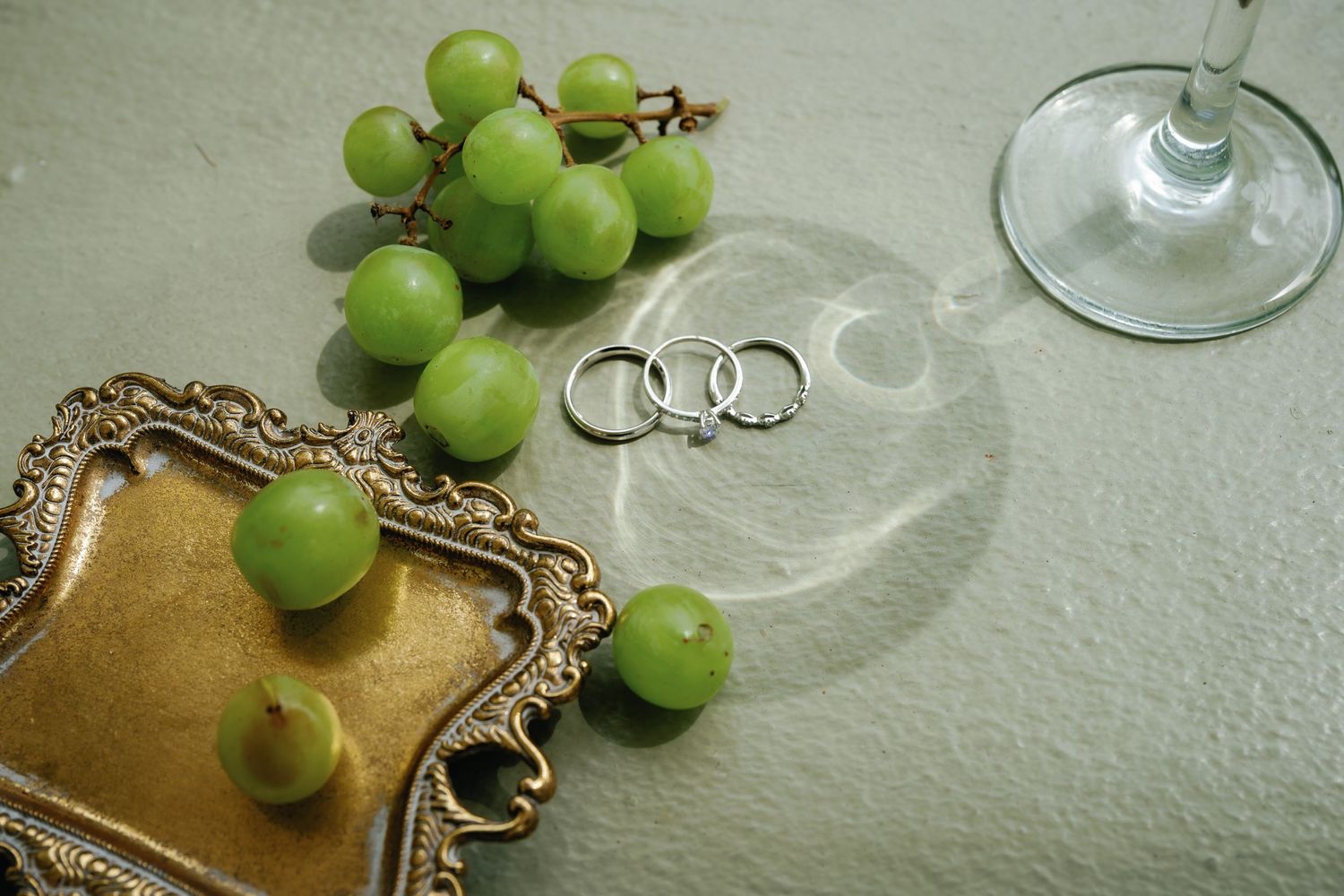 Fresh green grapes and wine glasses arranged on an elegant table setting.