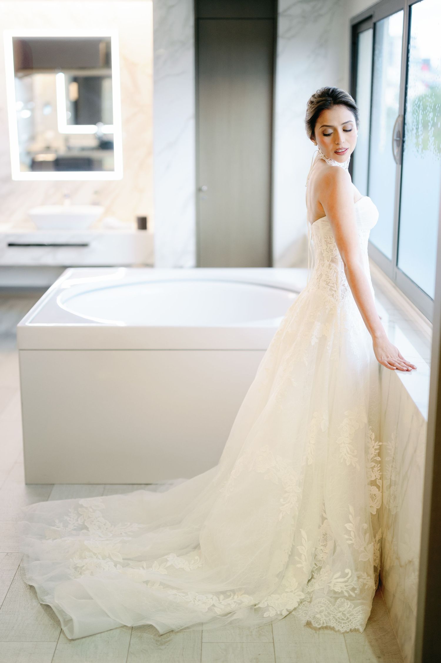 Elegant bridal portraits featuring a flowing white wedding gown with lace details against a bright window backdrop.