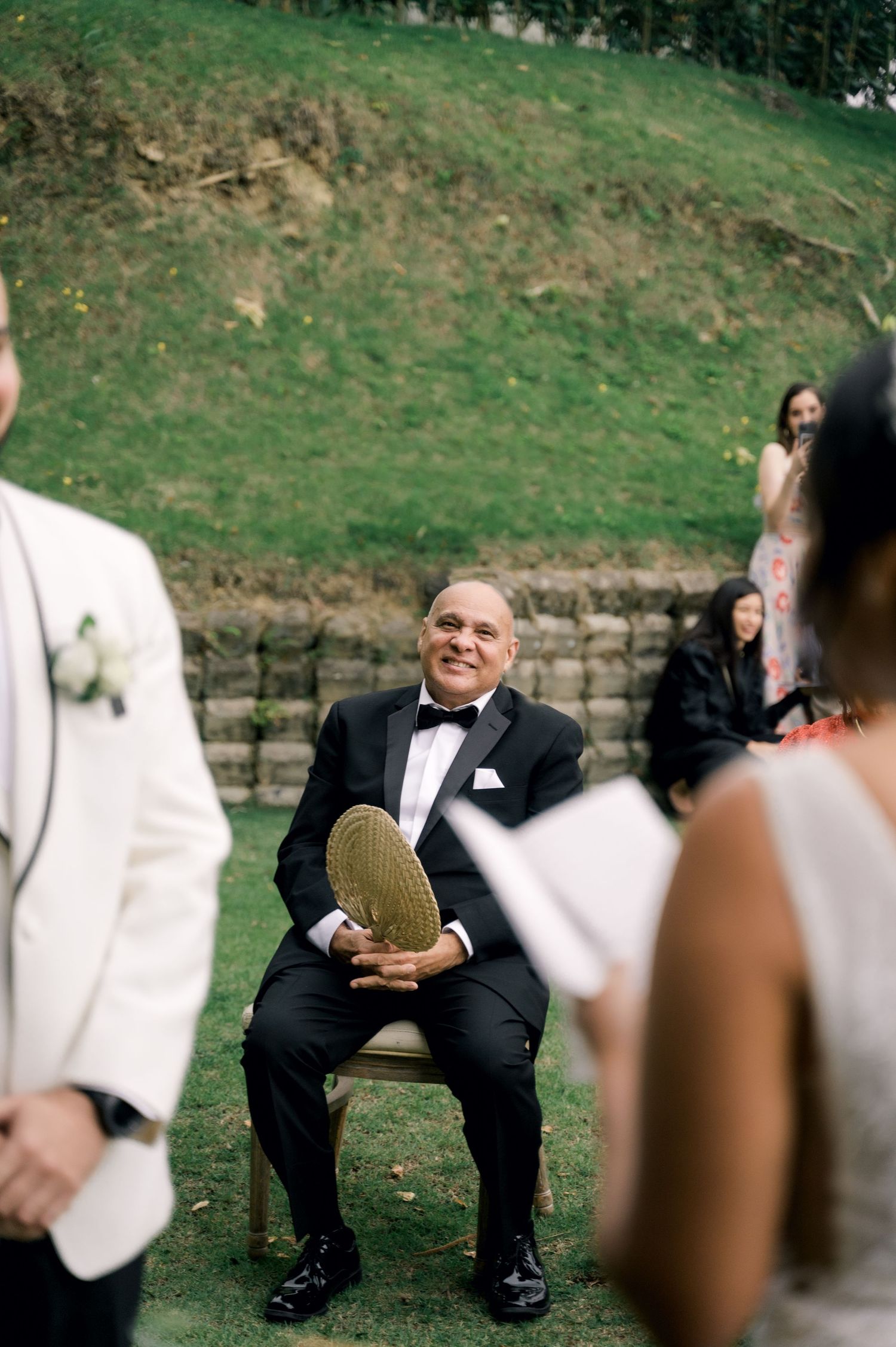 A sequence of four photos showing a person sitting outdoors in formal attire on a grassy slope.