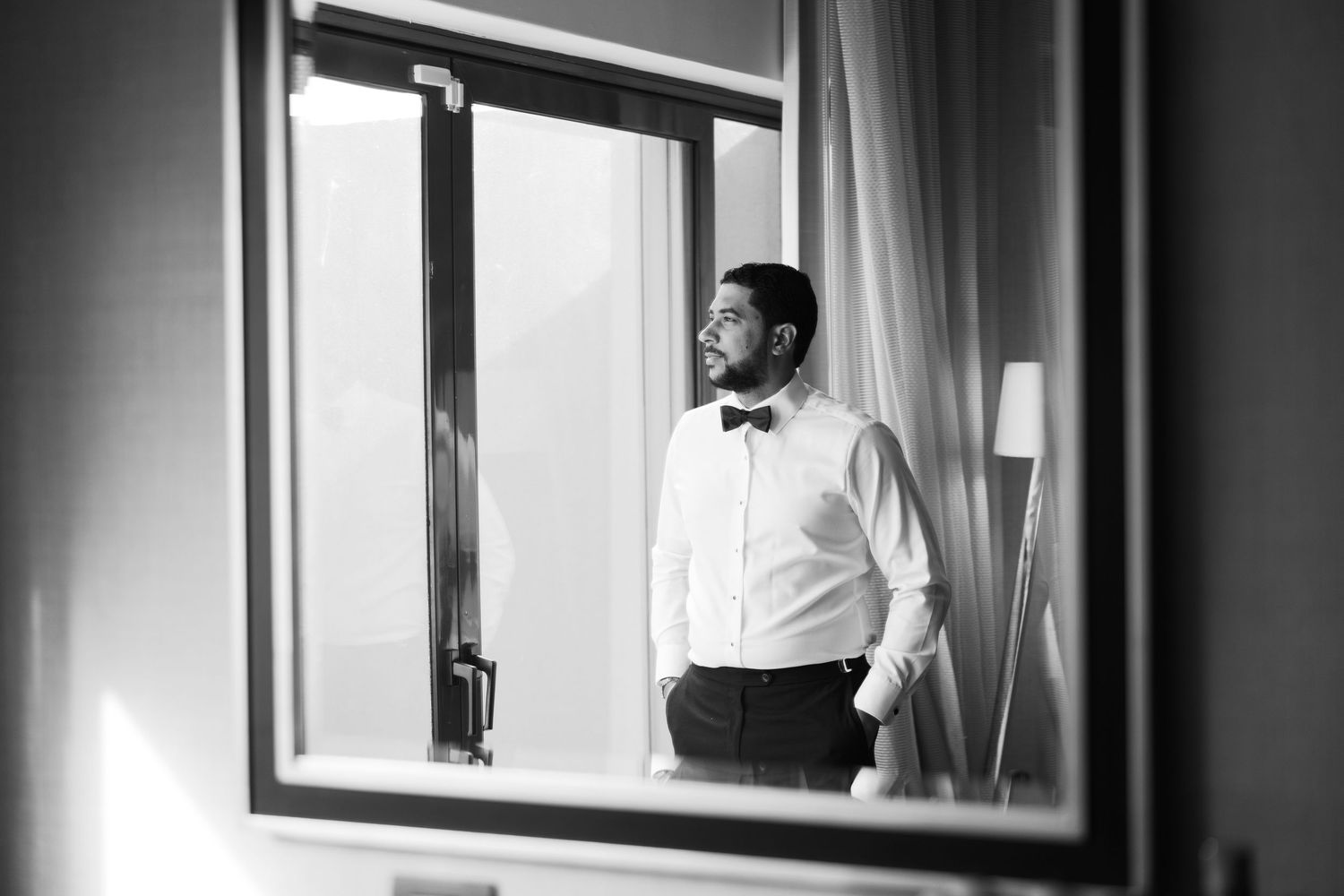 Black and white photo of formal attire preparations near a window.
