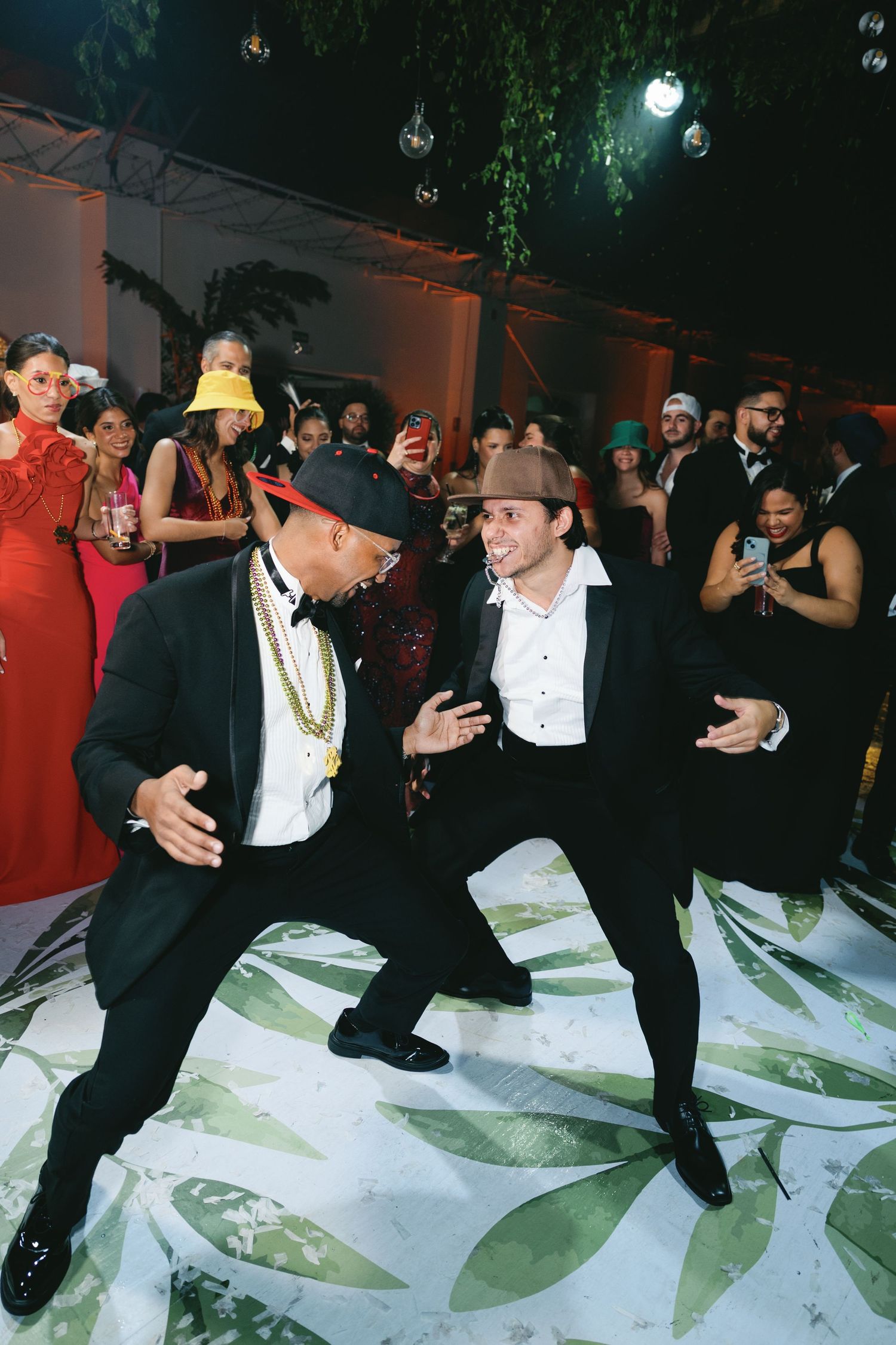 Group of dancers performing synchronized moves on a white dance floor at a party.