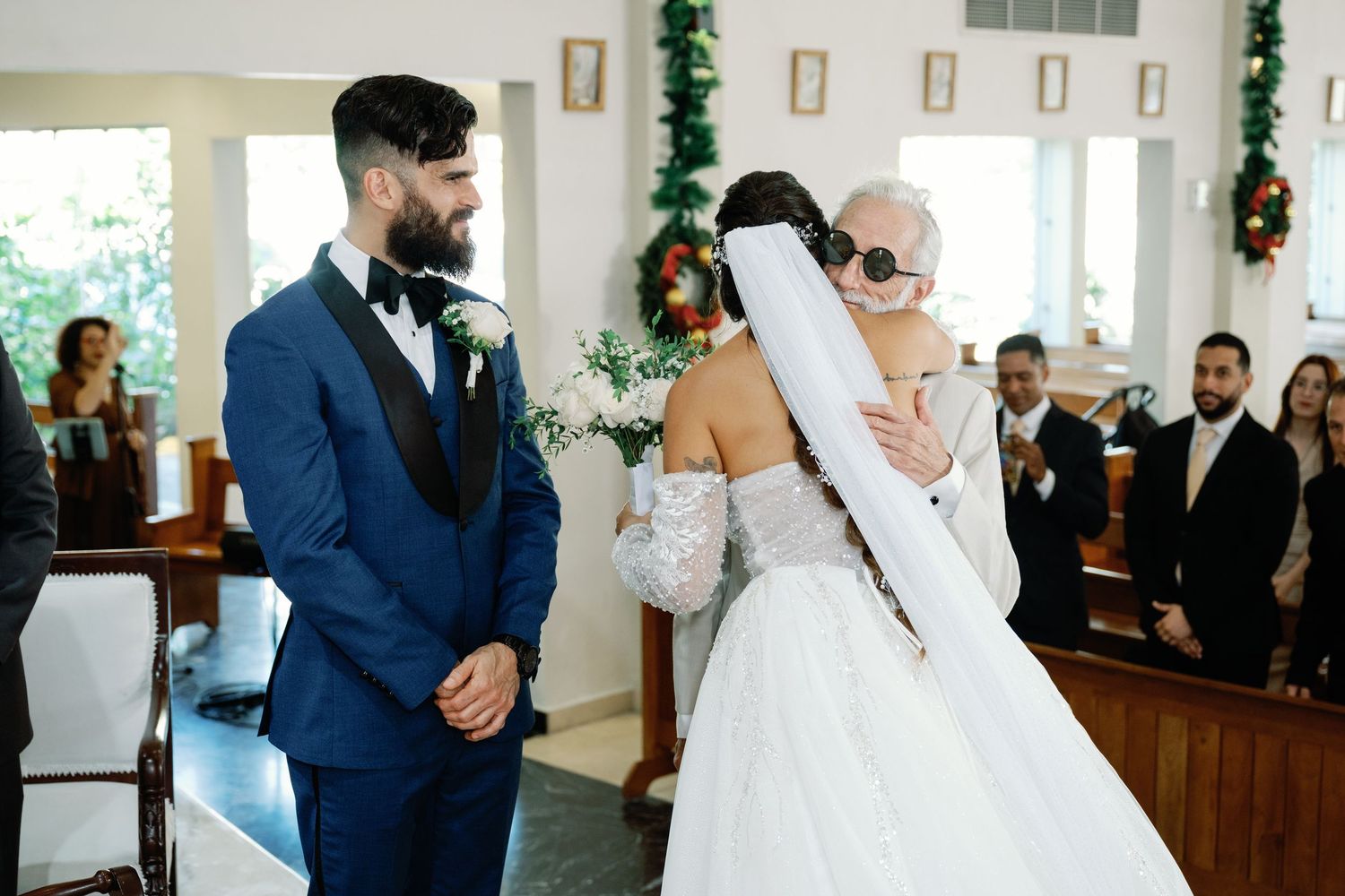 Newlywed couple shares their first dance at an elegant wedding reception with guests watching in the background.