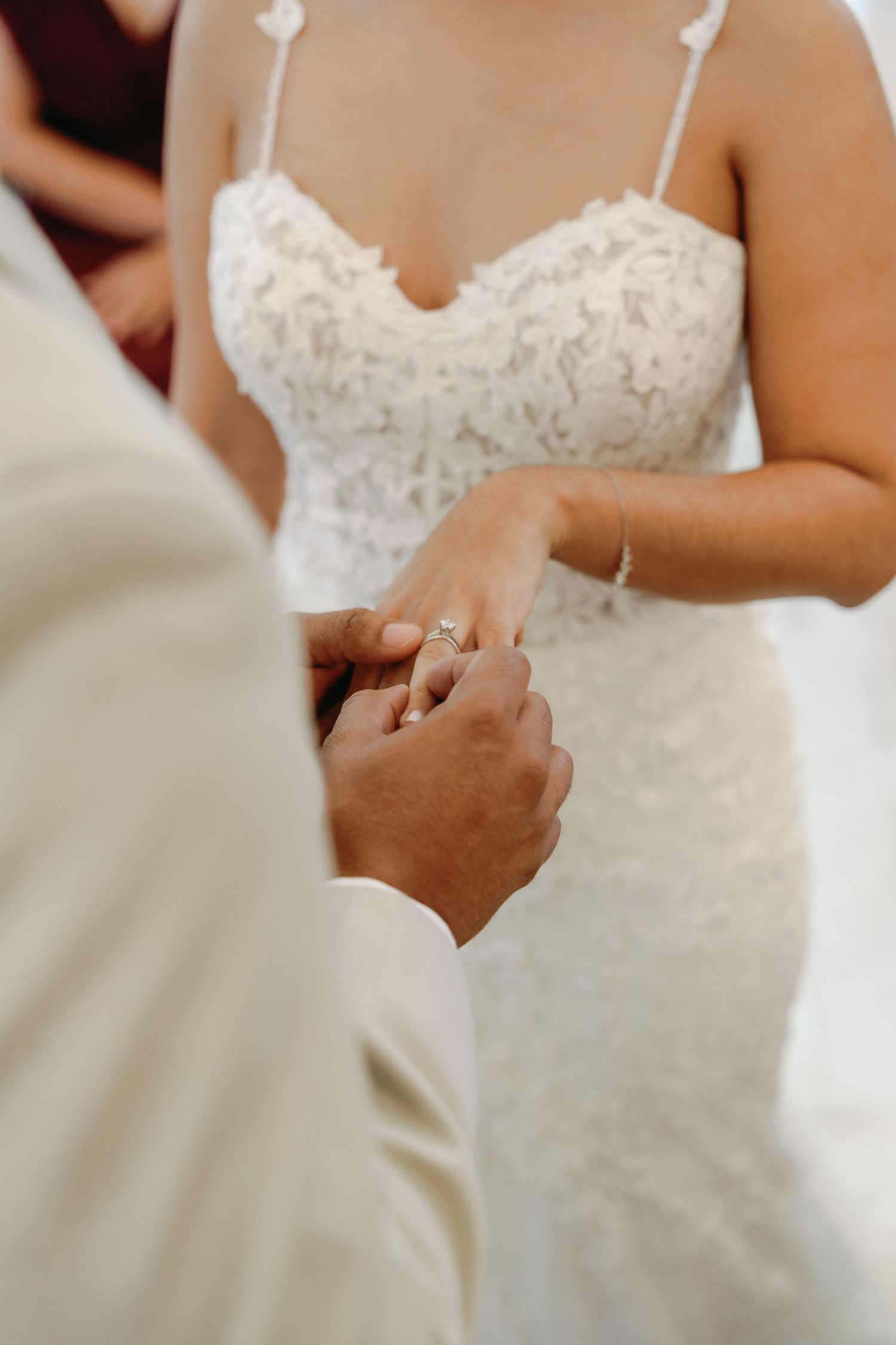 Close-up of hands exchanging wedding rings during an intimate ceremony moment.