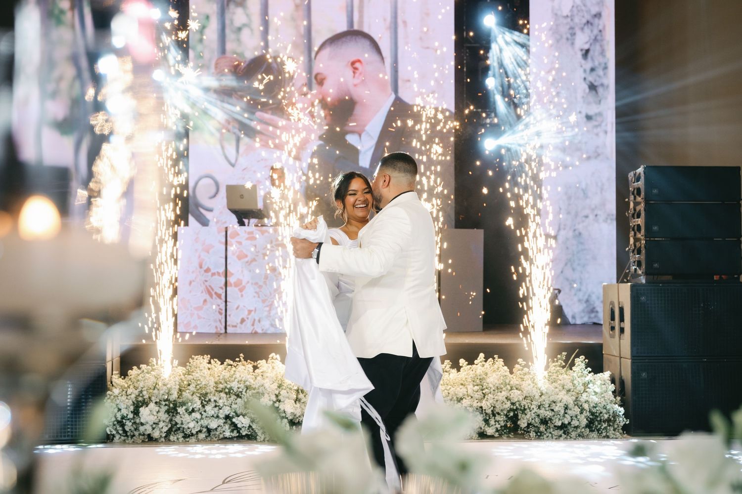 A wedding celebration with sparklers creating a magical light tunnel effect as guests hold them overhead during the evening.