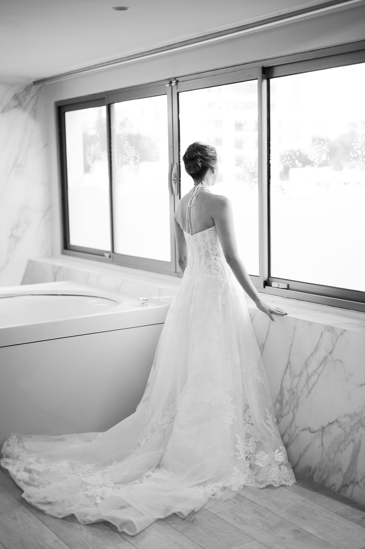 A flowing white wedding dress with intricate lace details cascades elegantly across a sunlit room.