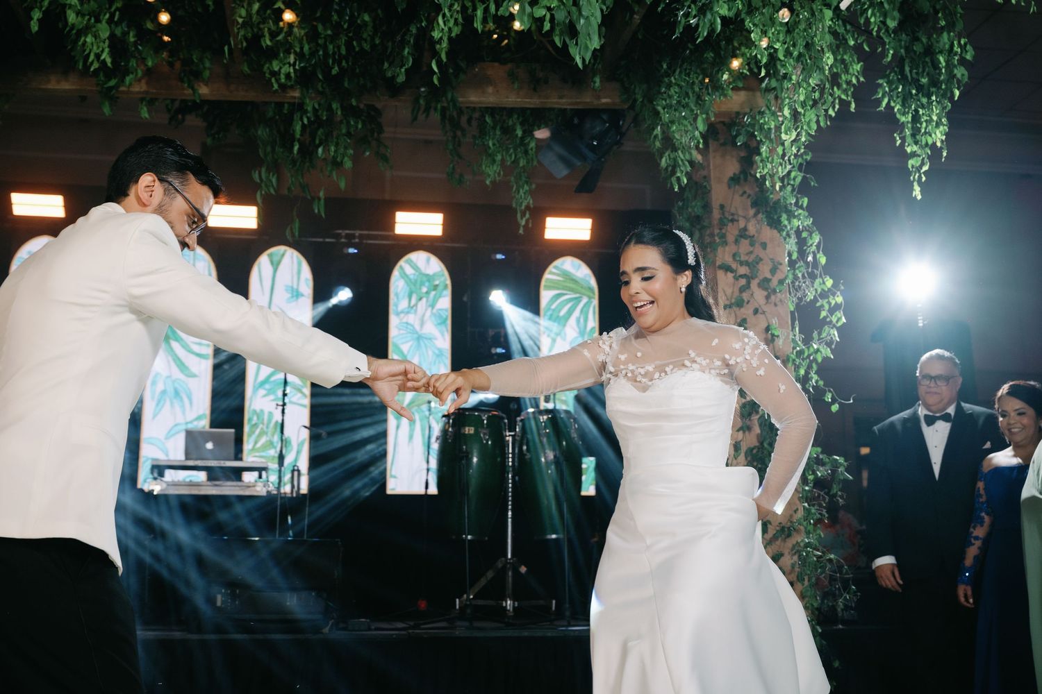 Wedding guests dance and celebrate together on a lively dance floor during an evening reception.