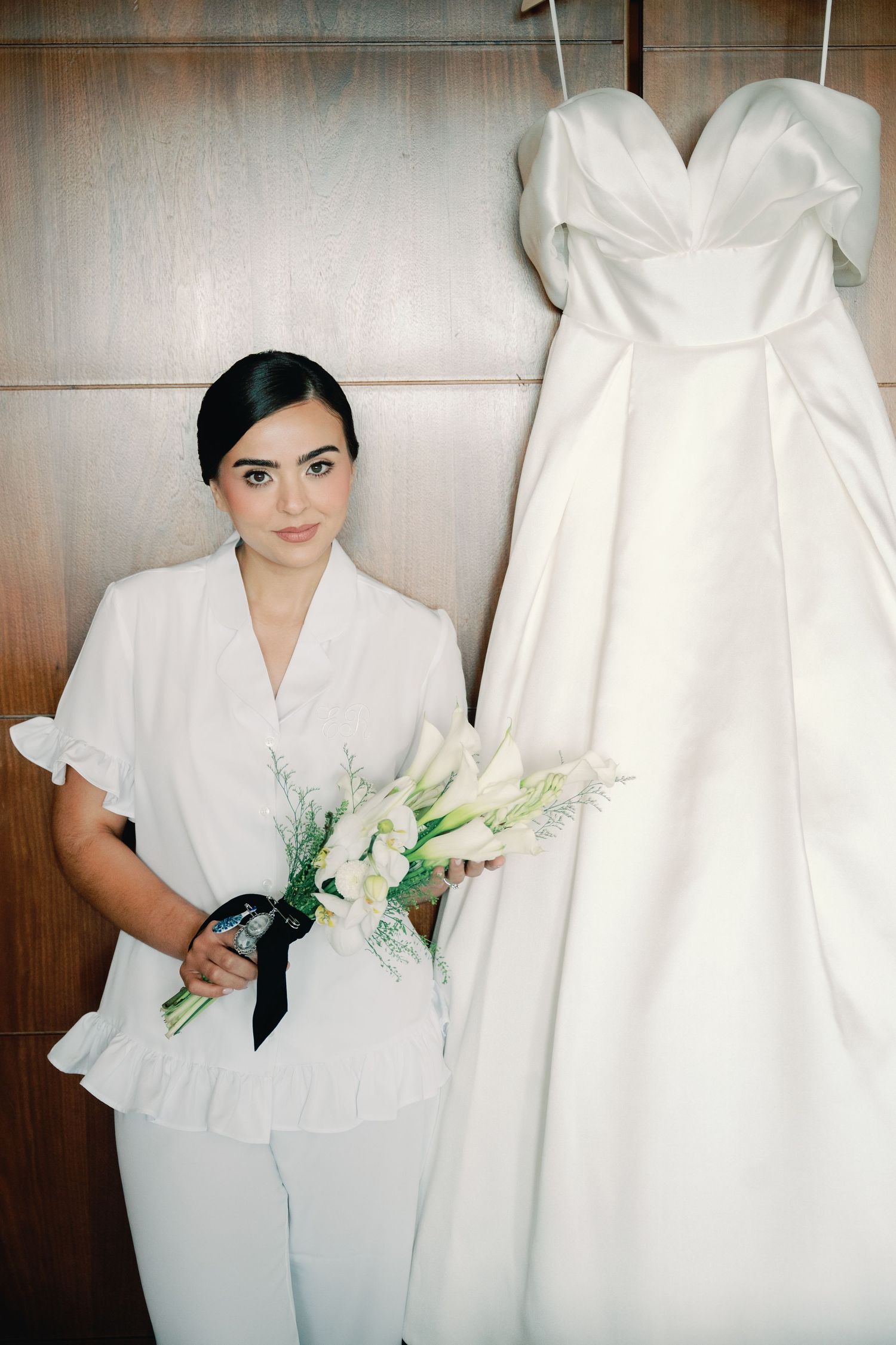 A series of wedding preparation photos showing a white bridal gown and someone in white attire holding delicate floral bouquets.
