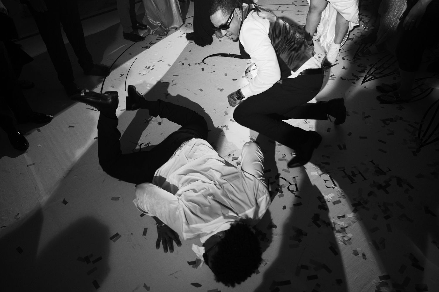 Black and white photo showing people dancing and moving energetically at what appears to be a concert or party.