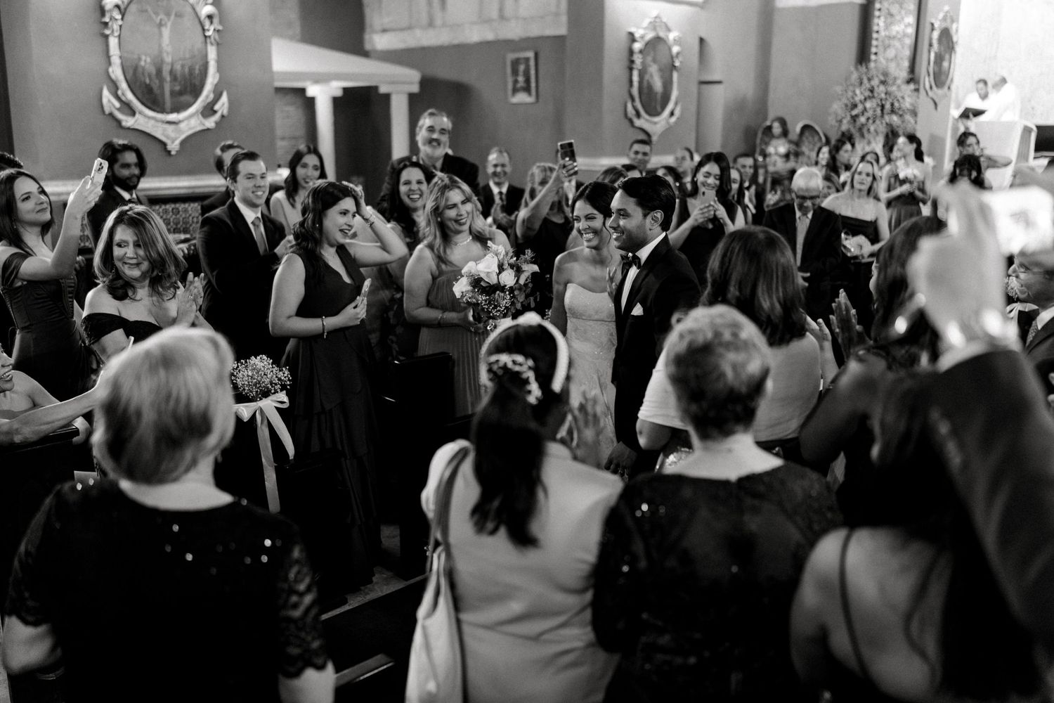 Wedding guests dance and celebrate together on a crowded dance floor during an indoor reception.