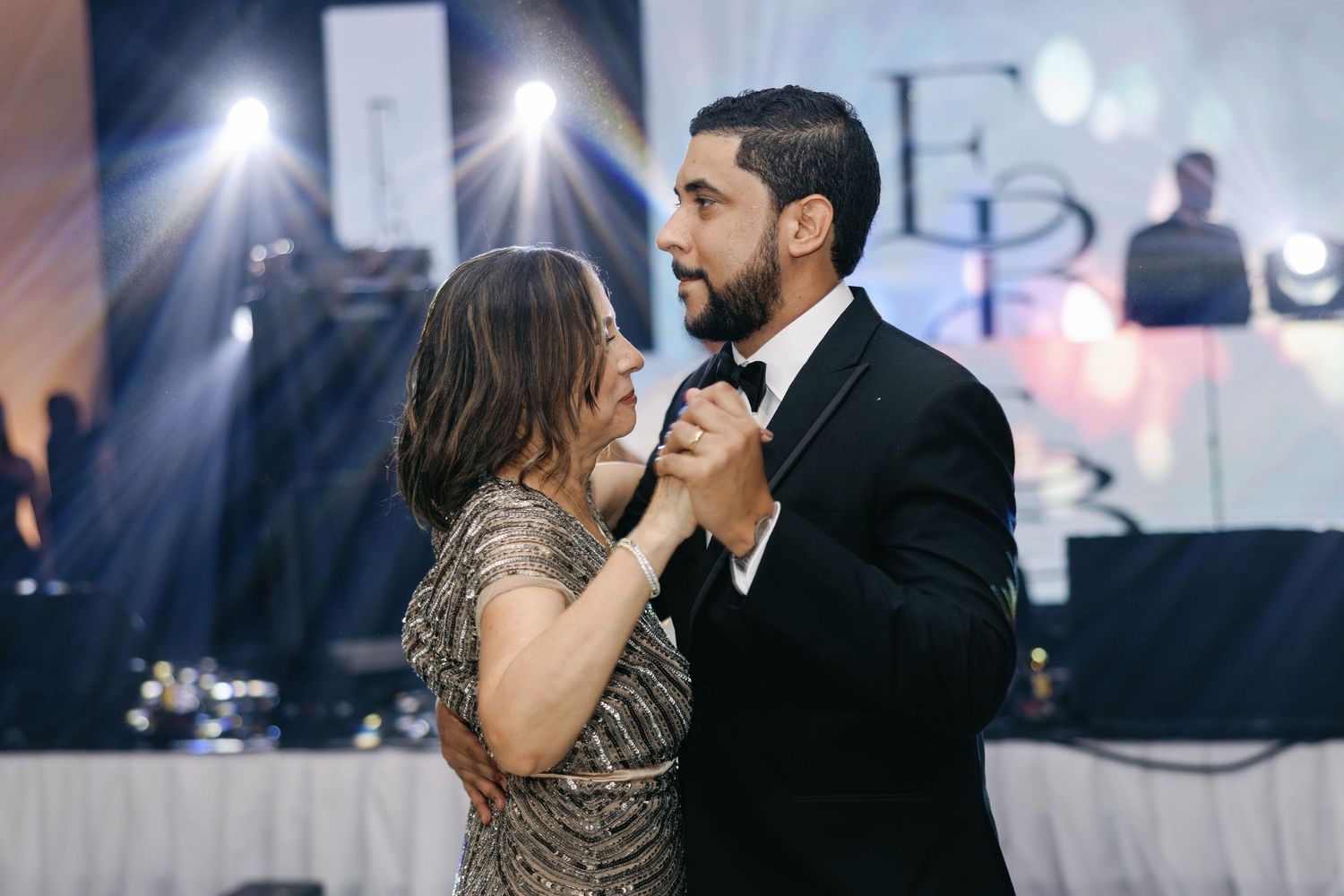 Romantic wedding reception dance sequence showing multiple intimate moments between newlyweds under elegant lighting.