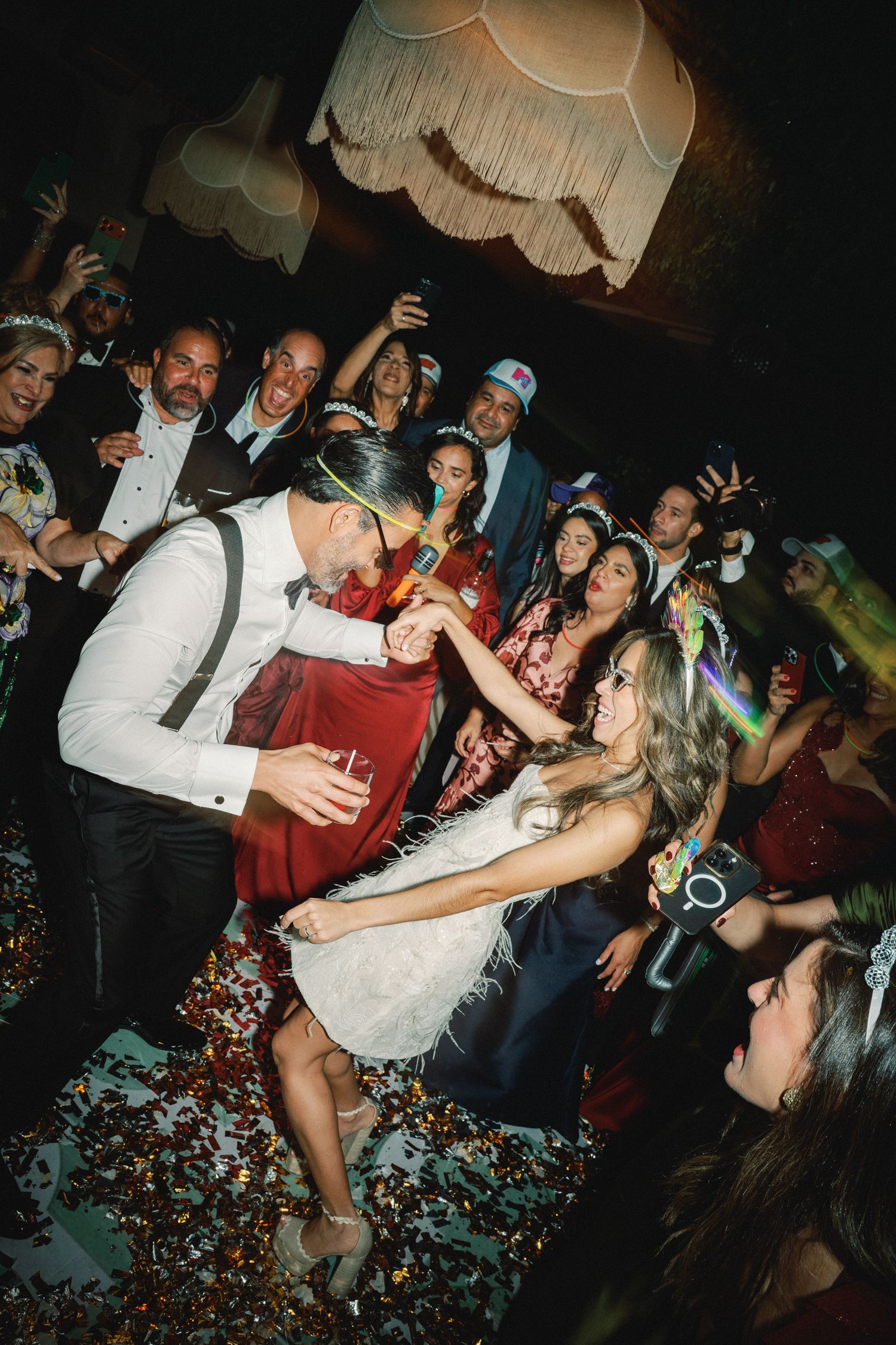 Energetic crowd celebrates at a nightclub event with confetti flying through the air.