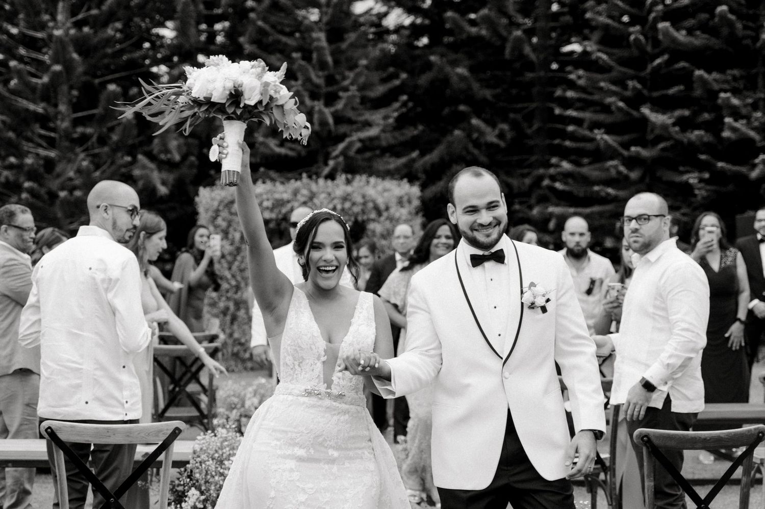 A black and white wedding photo collage showing candid moments of celebration and dancing at an outdoor reception.
