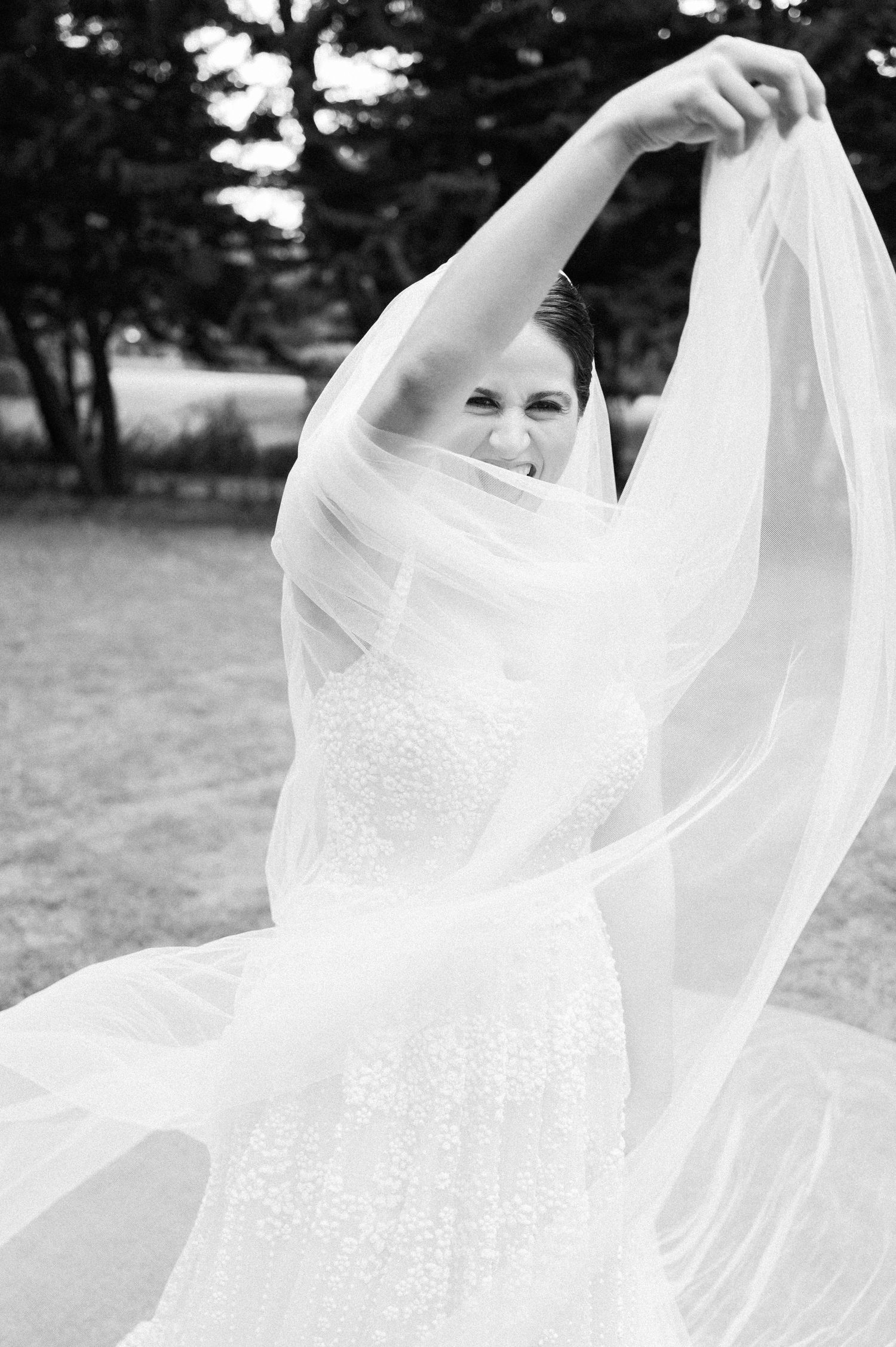 Flowing white wedding dress fabric billowing gracefully in black and white outdoor setting.