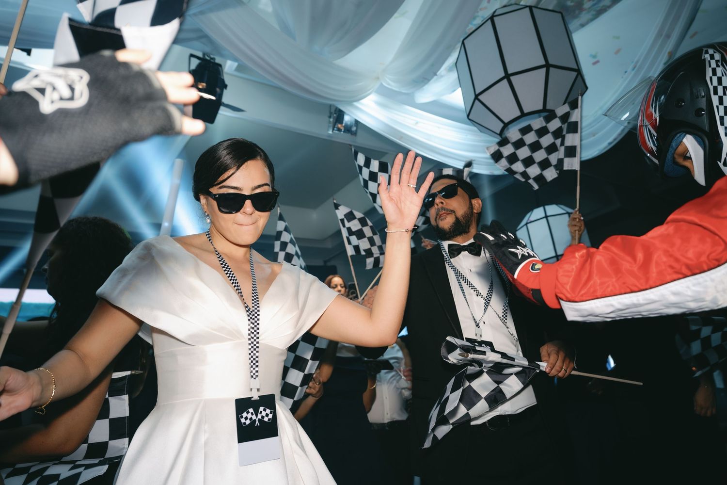 Partygoers enjoying a vibrant nightclub atmosphere under draped white fabric and blue ambient lighting.