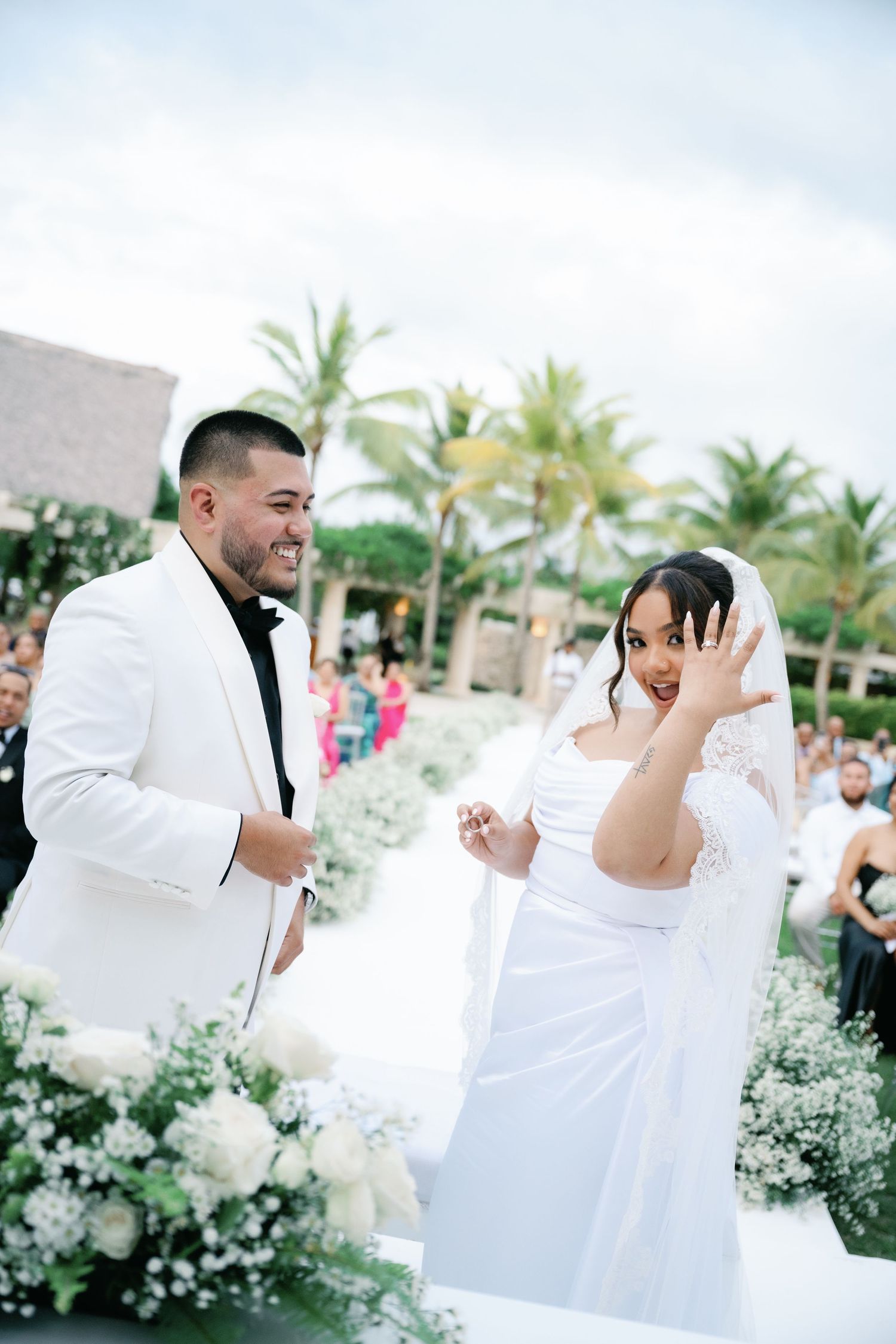 A joyful wedding celebration sequence showing a couple in white attire sharing candid laughter and emotions outdoors.