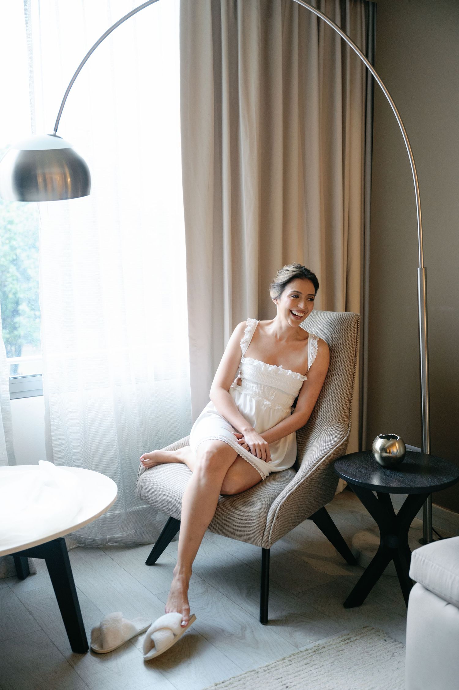 A series of relaxed bridal portraits showing someone lounging in a white chair near a modern floor lamp.