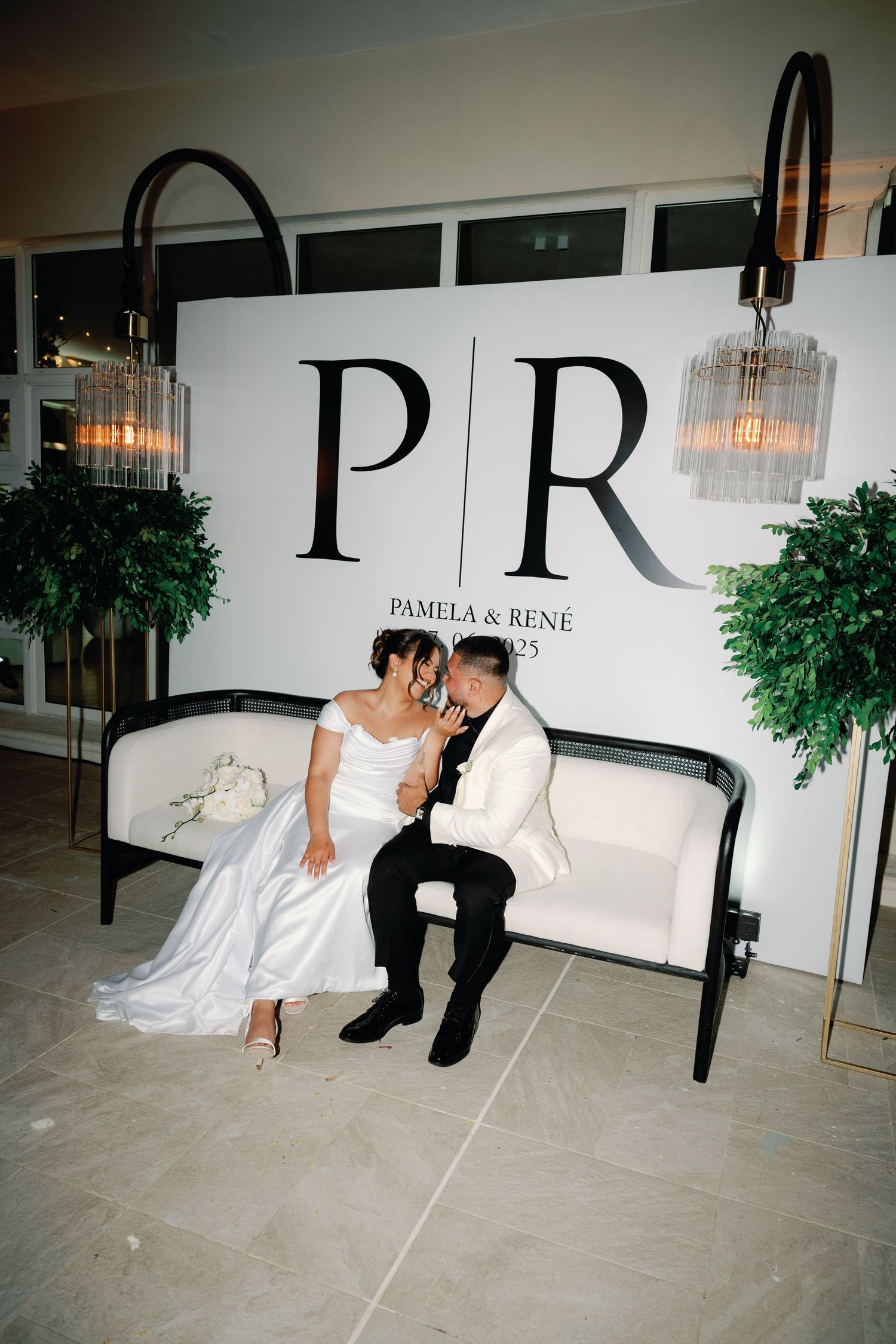 Romantic wedding photo series showing couple posing on floor against white wall with elegant signage.