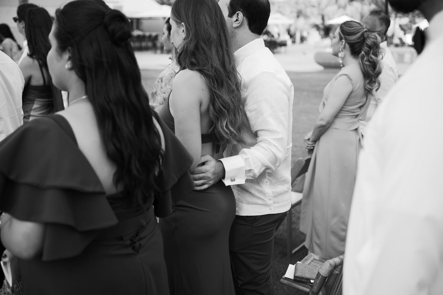 Black and white photo of wedding guests mingling and socializing at a reception.