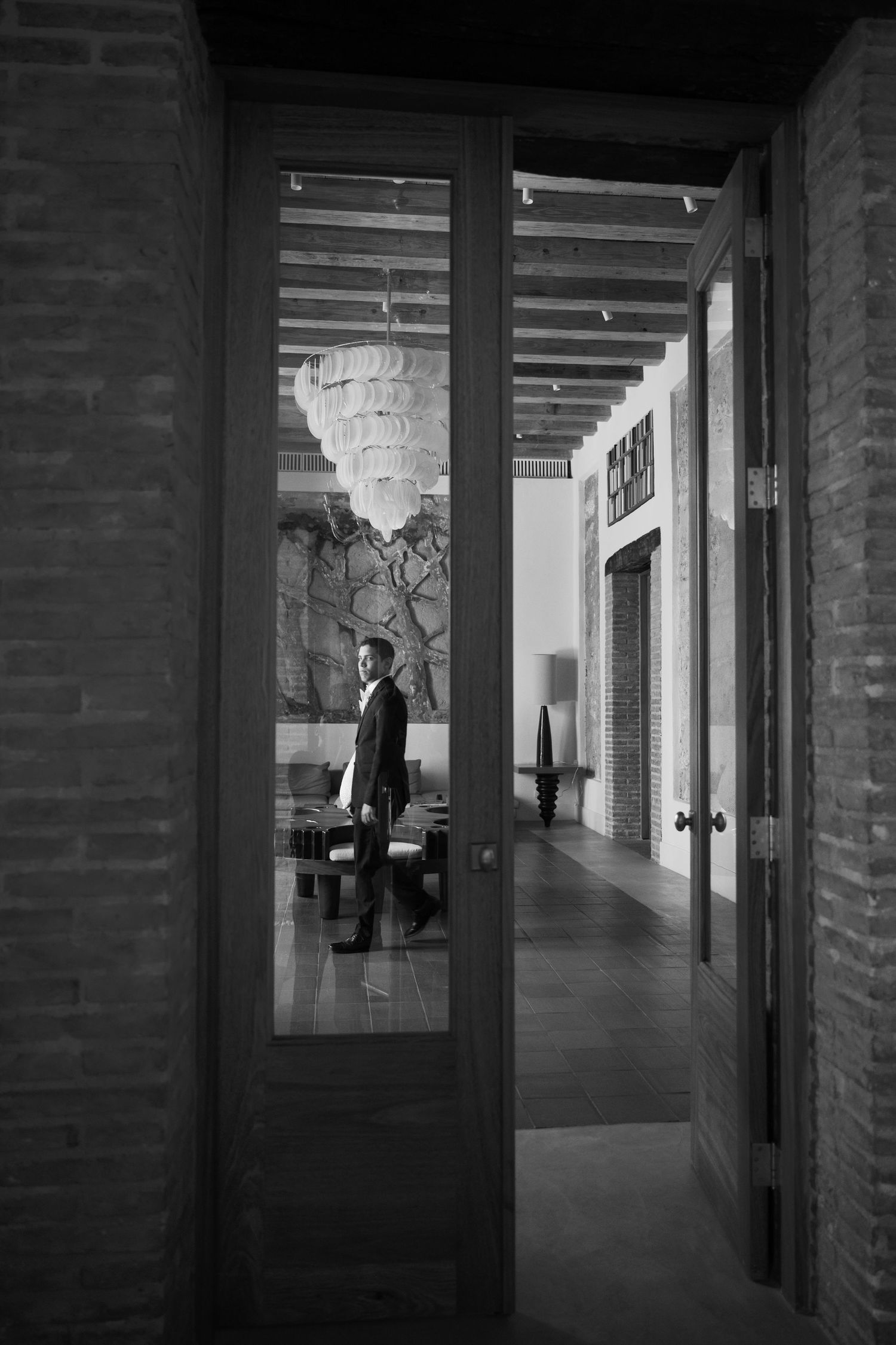 Series of architectural frames showing a person walking through a minimalist corridor with brick walls.