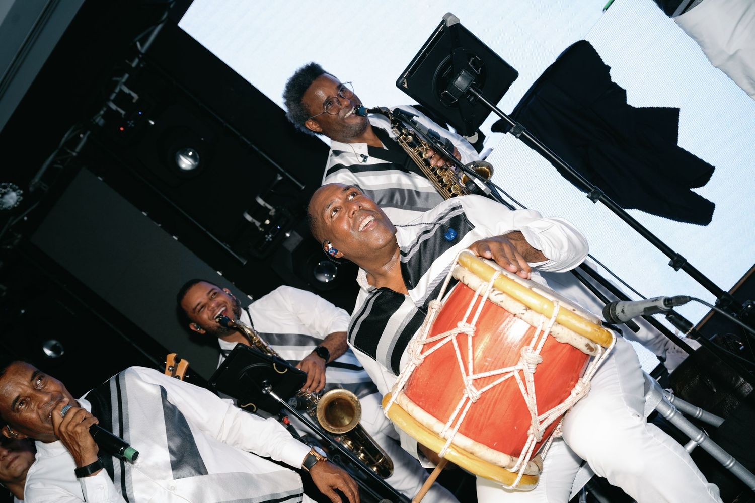 Musicians working in a recording studio with instruments and equipment.