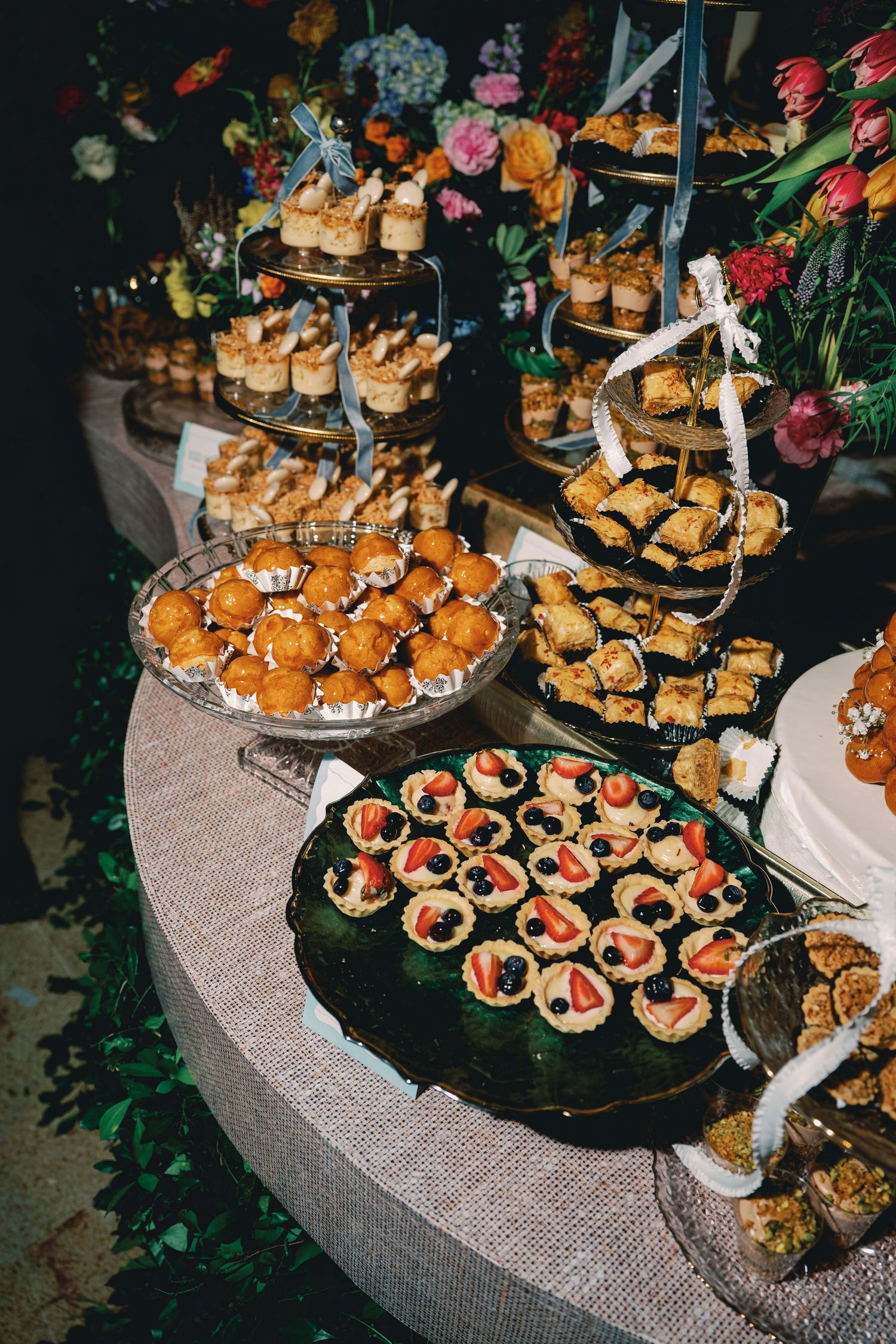 Elegant display of catered appetizers and desserts arranged on tiered platters at an upscale event.