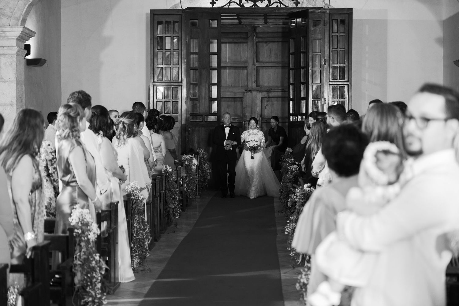 Wedding guests dance and celebrate on a black and white checkered dance floor at an elegant reception.