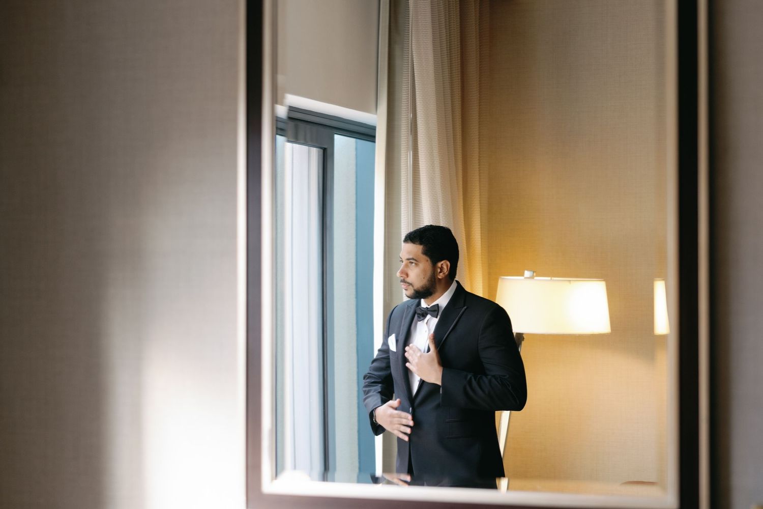 Wedding preparation scene with warm lighting and formal attire silhouettes.