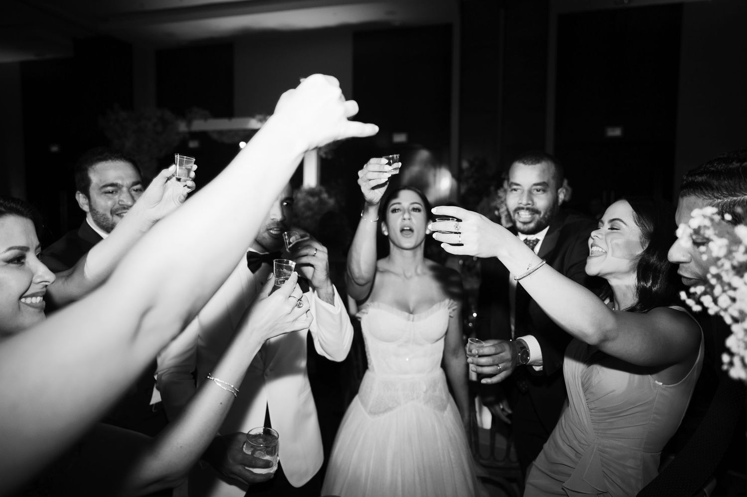 A black and white photo sequence showing a wedding reception dance party with people celebrating on the dance floor.