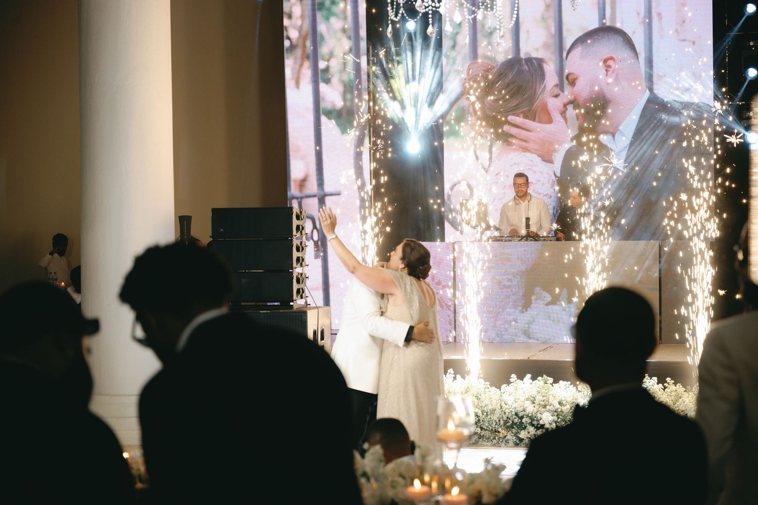 Wedding reception venue with dramatic lighting effects and sparklers creating magical atmosphere.