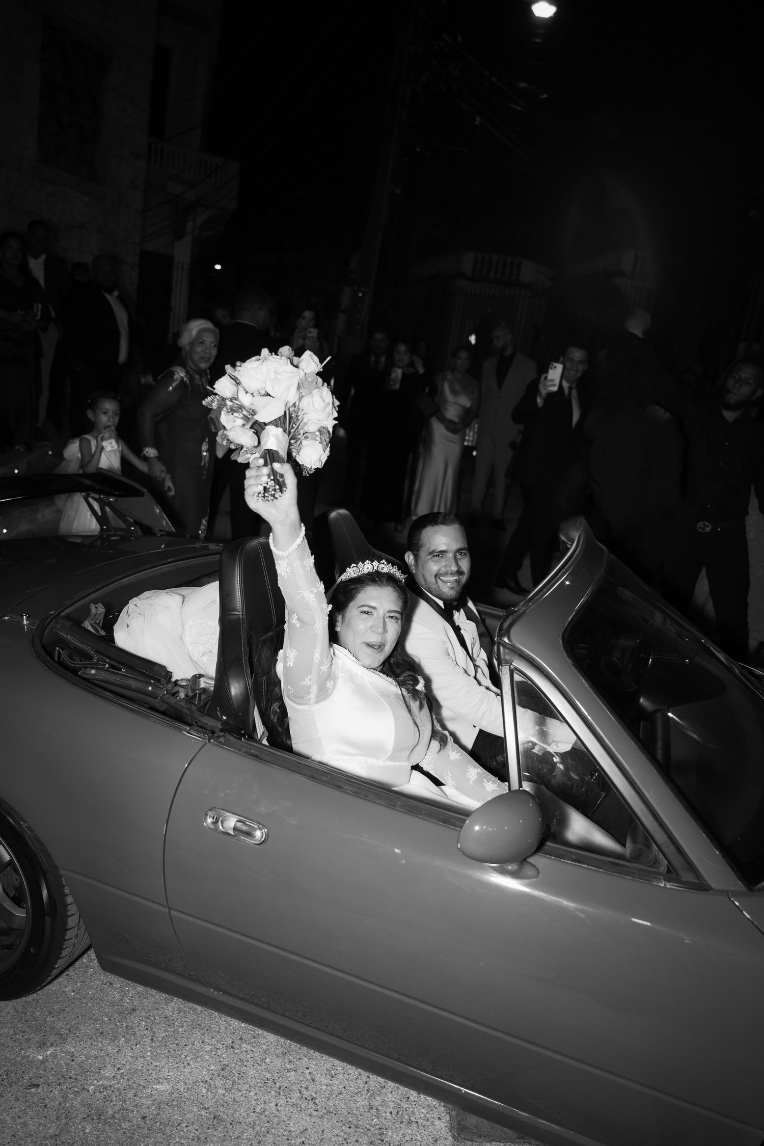 A series of black and white photos showing newlyweds leaving in a convertible car at night.