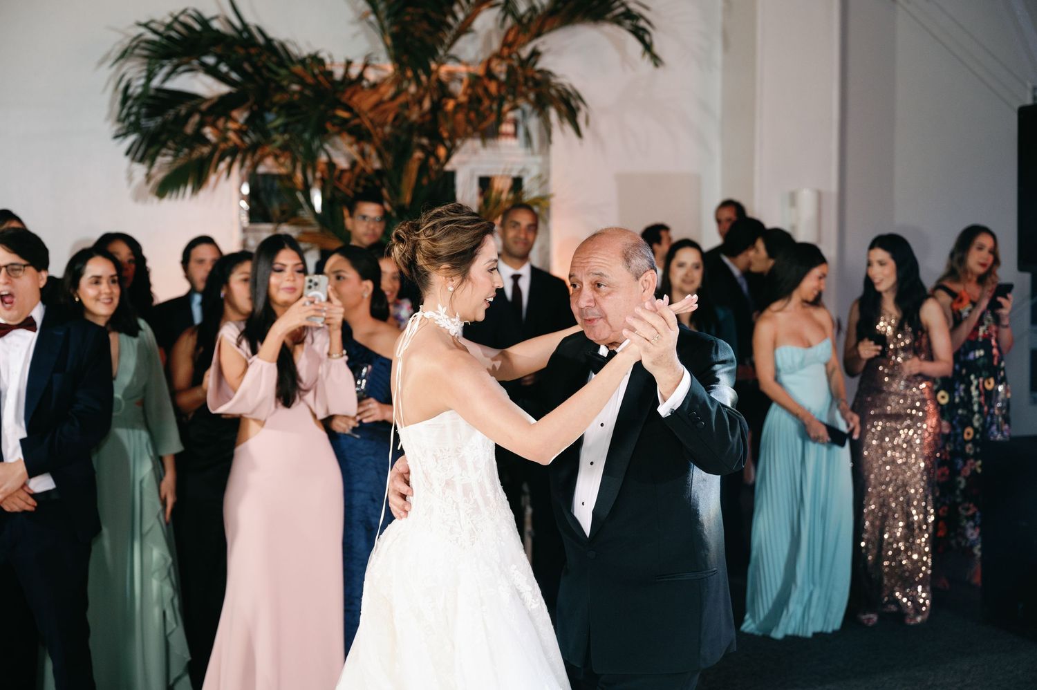 Wedding reception dance floor filled with guests in formal attire dancing and celebrating.