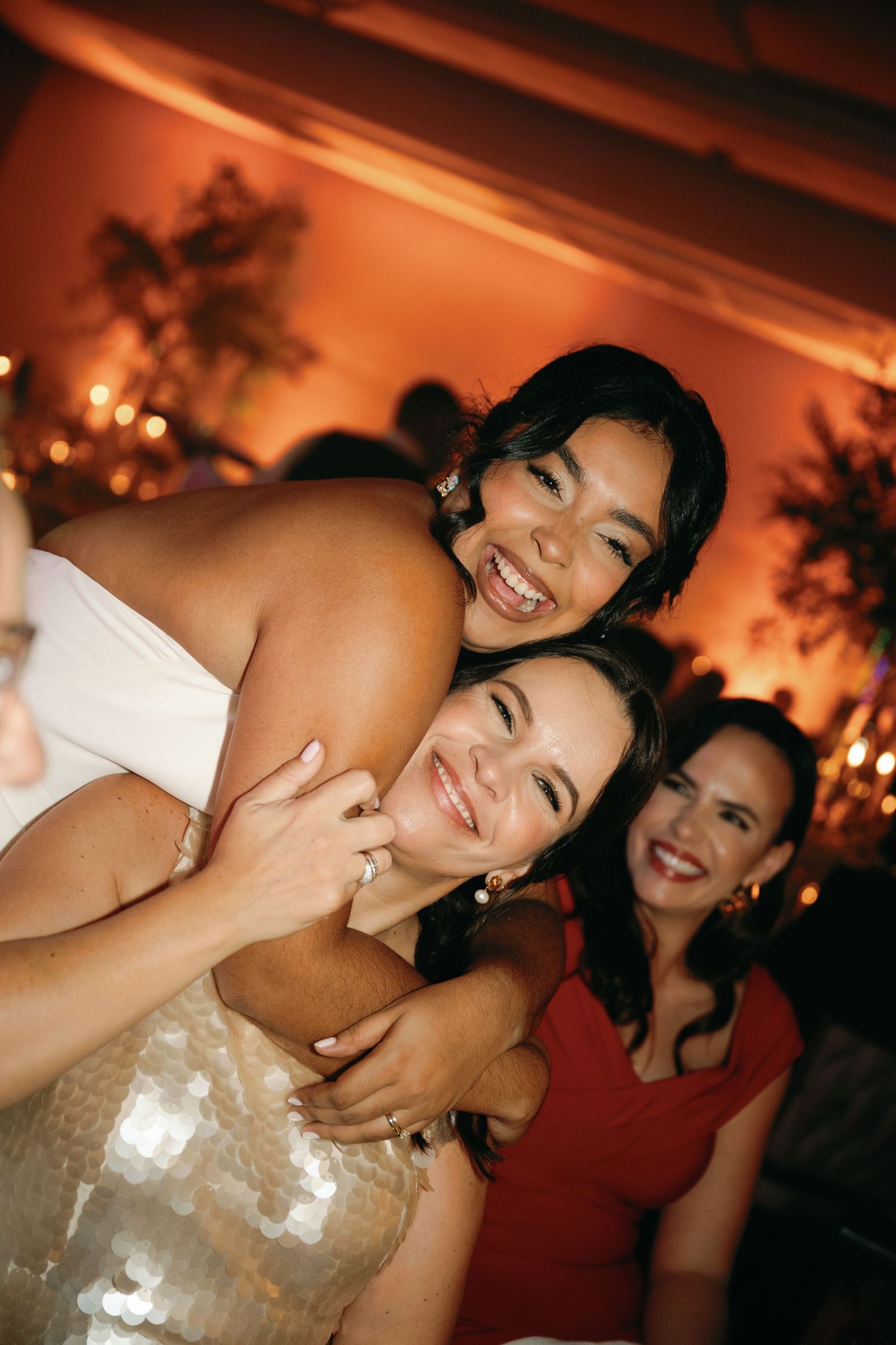A candlelit celebration shows joyful moments at an evening party with warm lighting and formal attire.