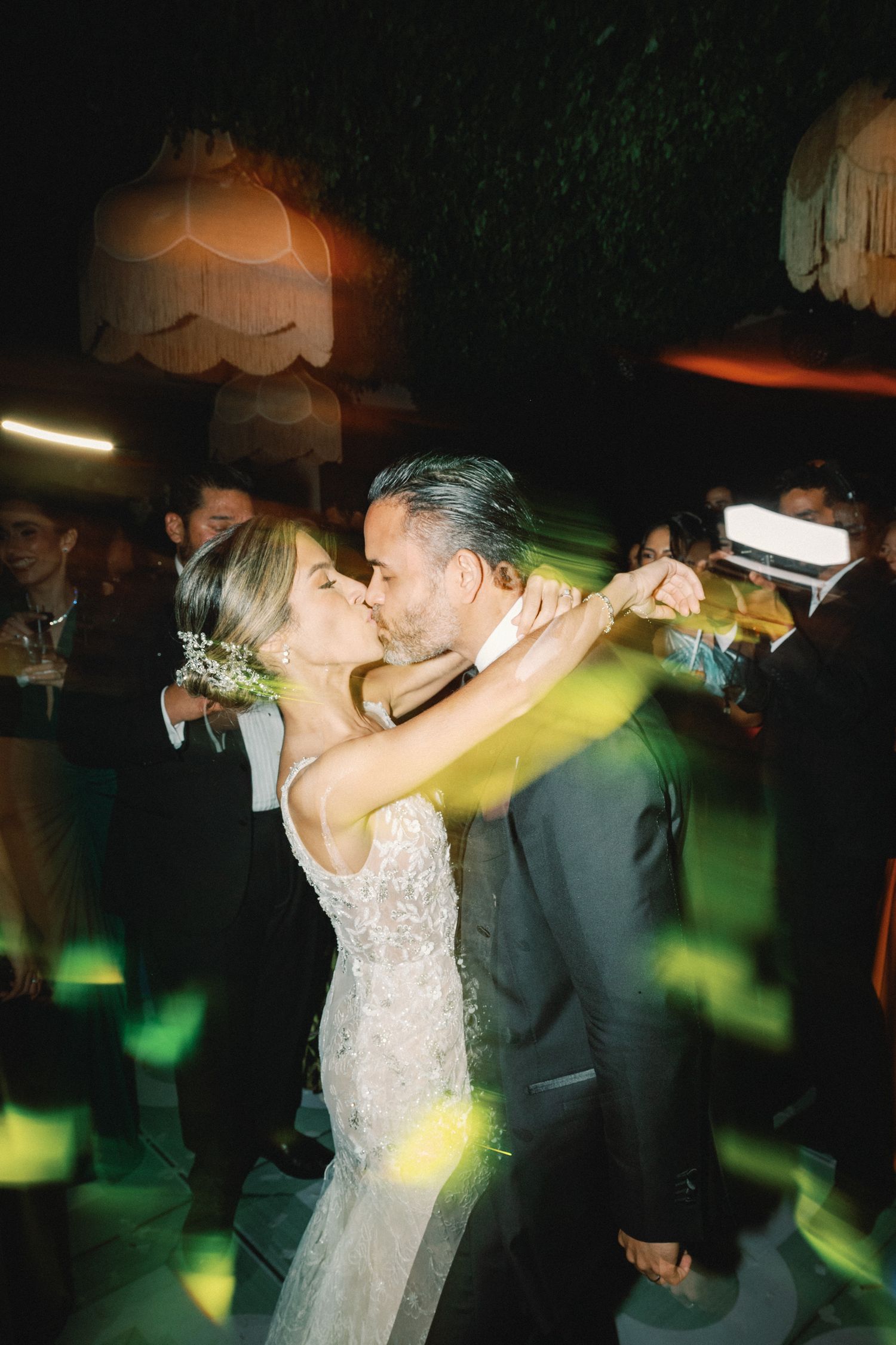 Wedding reception dance floor scene with colorful lights and motion blur effects.