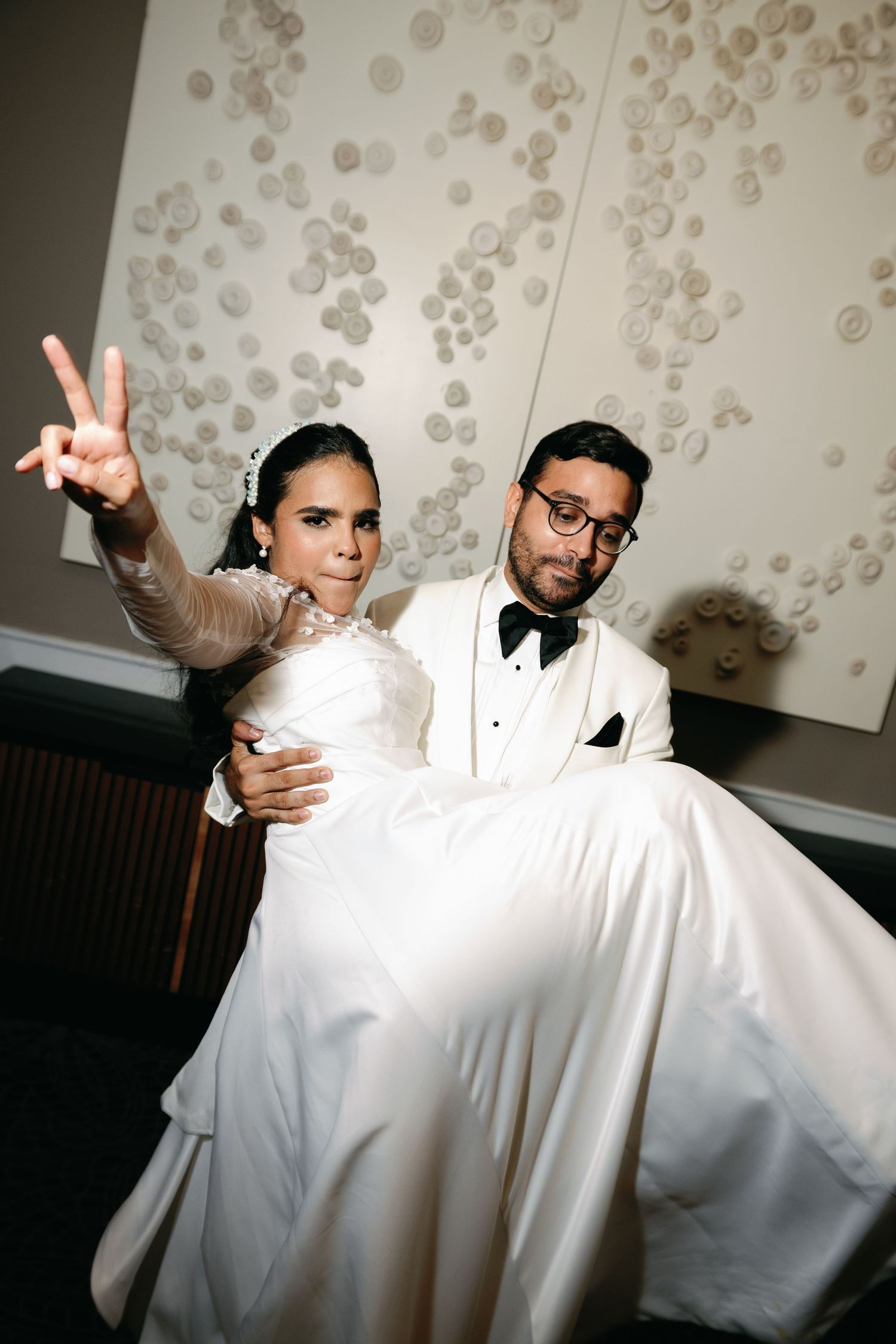 Artistic wedding dance photos showing playful poses against a decorative bubble-patterned backdrop.