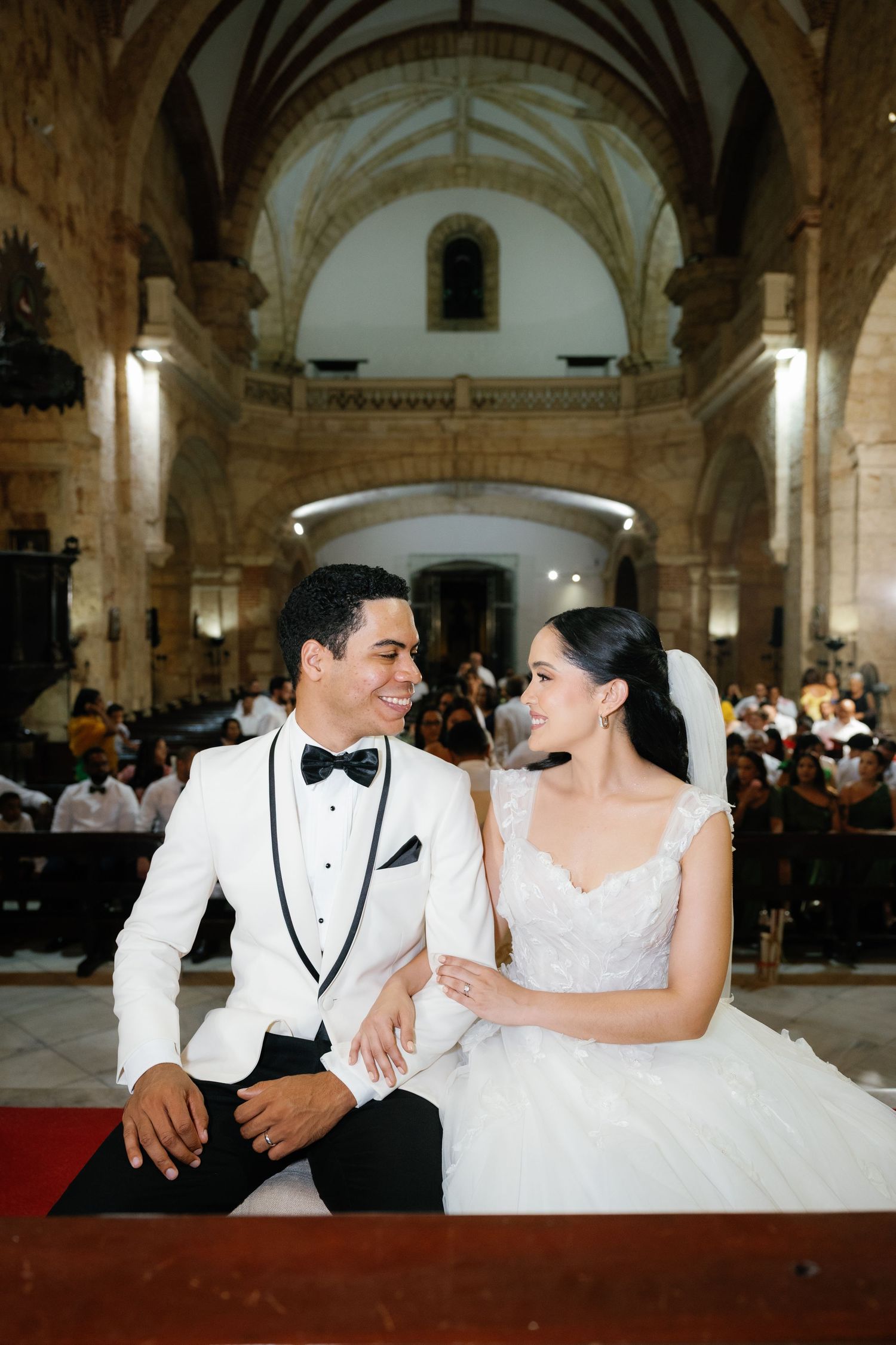 A couple shares a joyful moment together in an elegant church setting during their wedding ceremony.