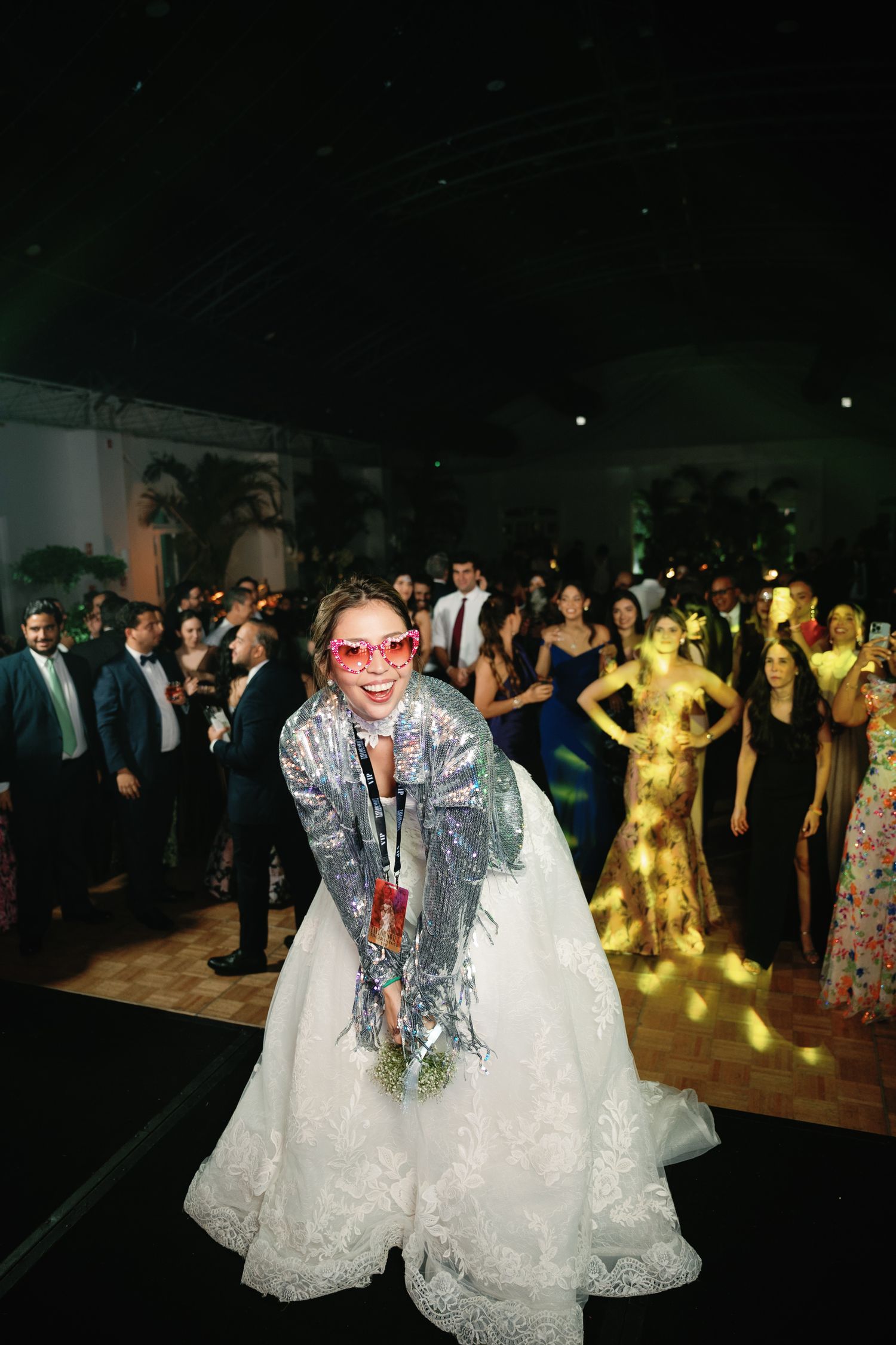 Wedding reception dance floor scene with guests celebrating in formal attire and colorful dresses.