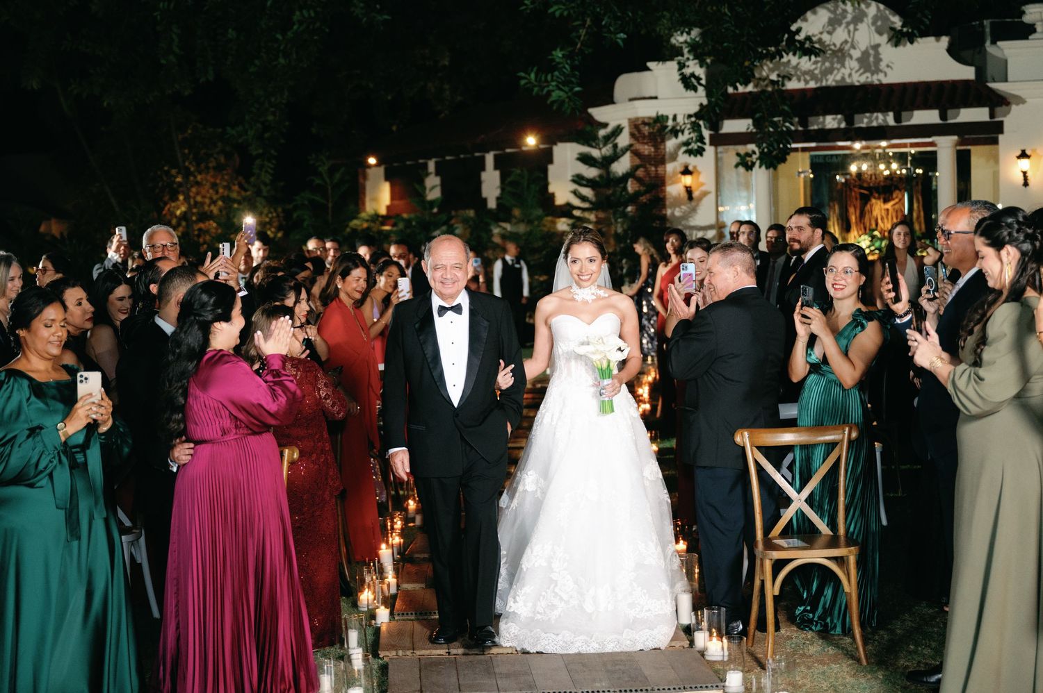 Wedding reception guests dance together on an illuminated dance floor during evening celebration.