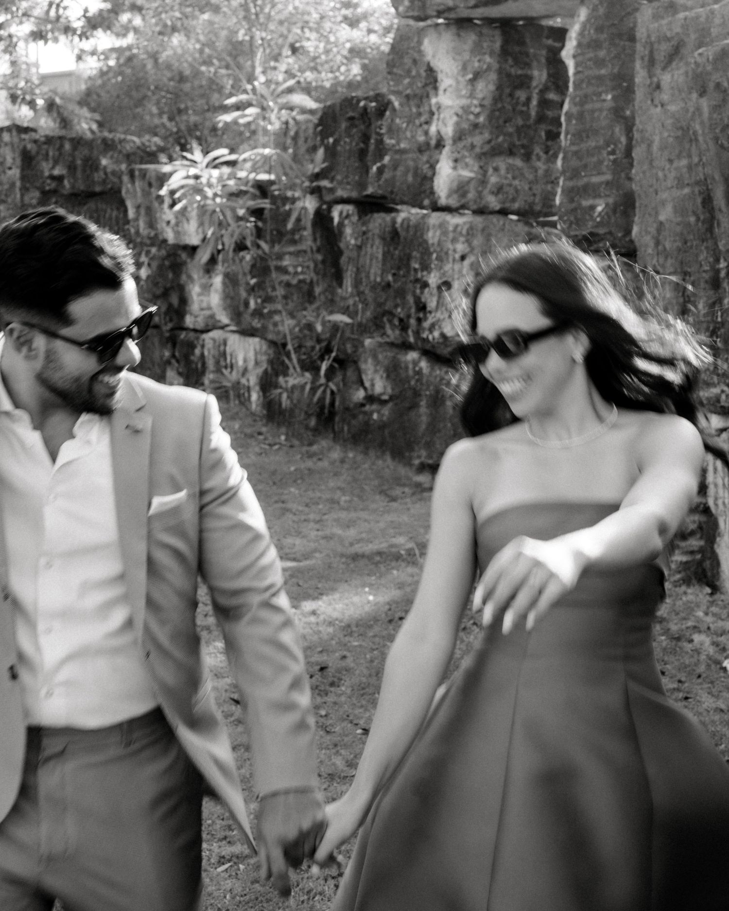 A sequence of black and white photographs showing a couple dancing and embracing in an outdoor garden setting.
