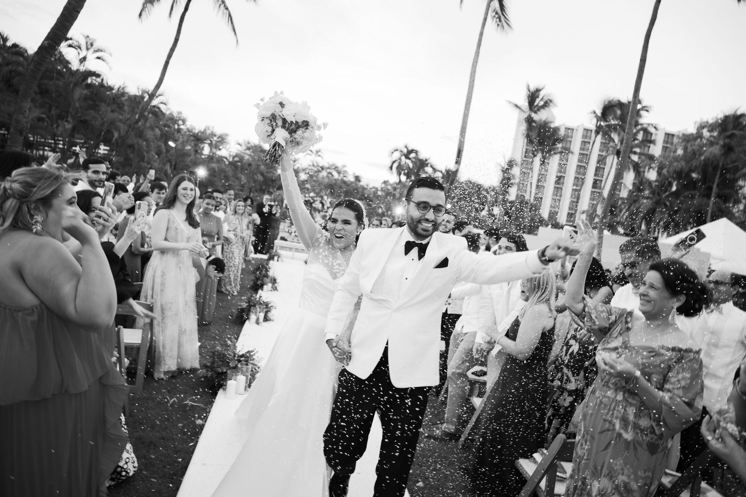 Black and white photo of wedding guests gathered outdoors for a celebration.