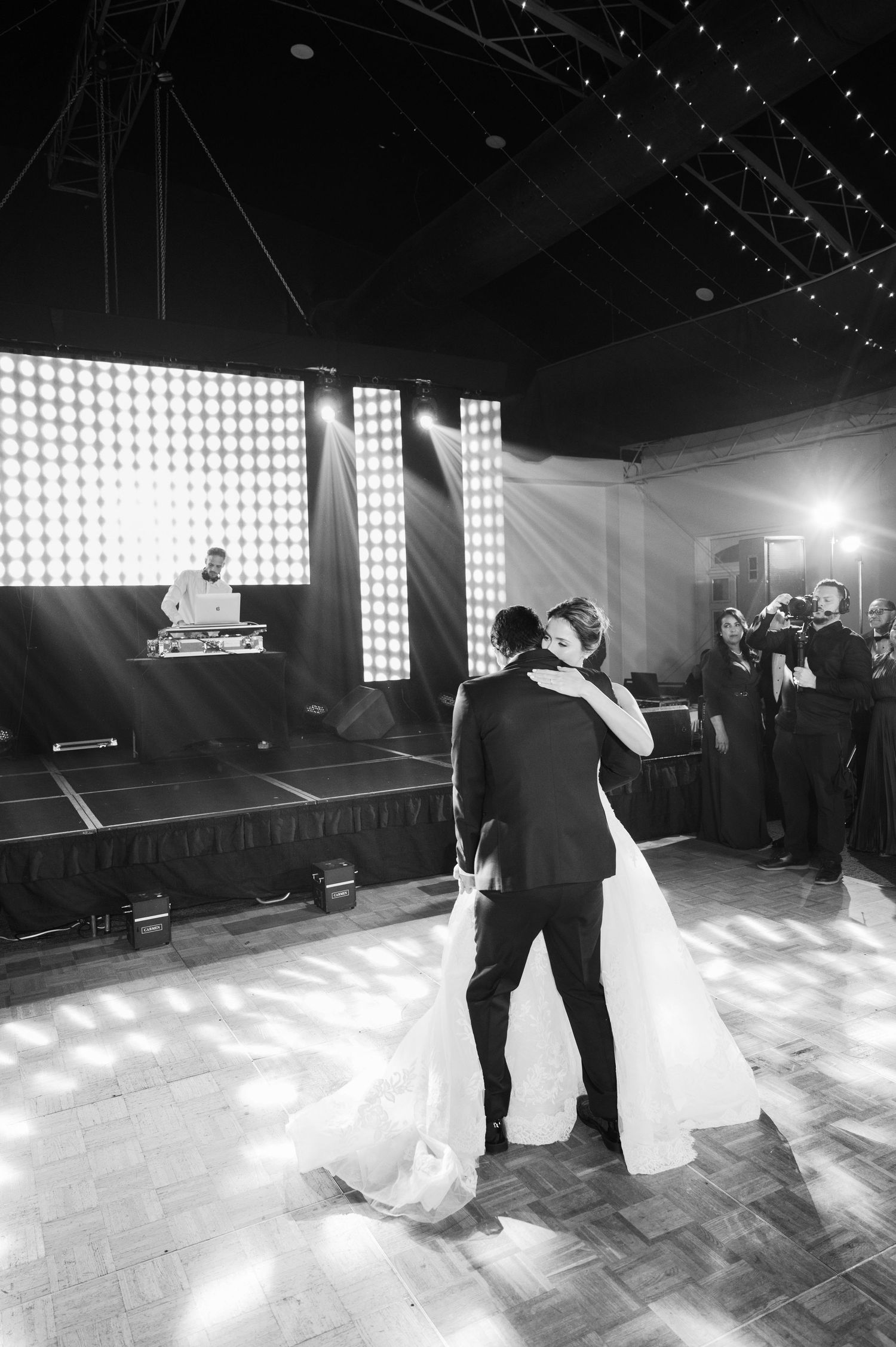 Black and white wedding dance photos showing couple's silhouettes against dramatic venue lighting.