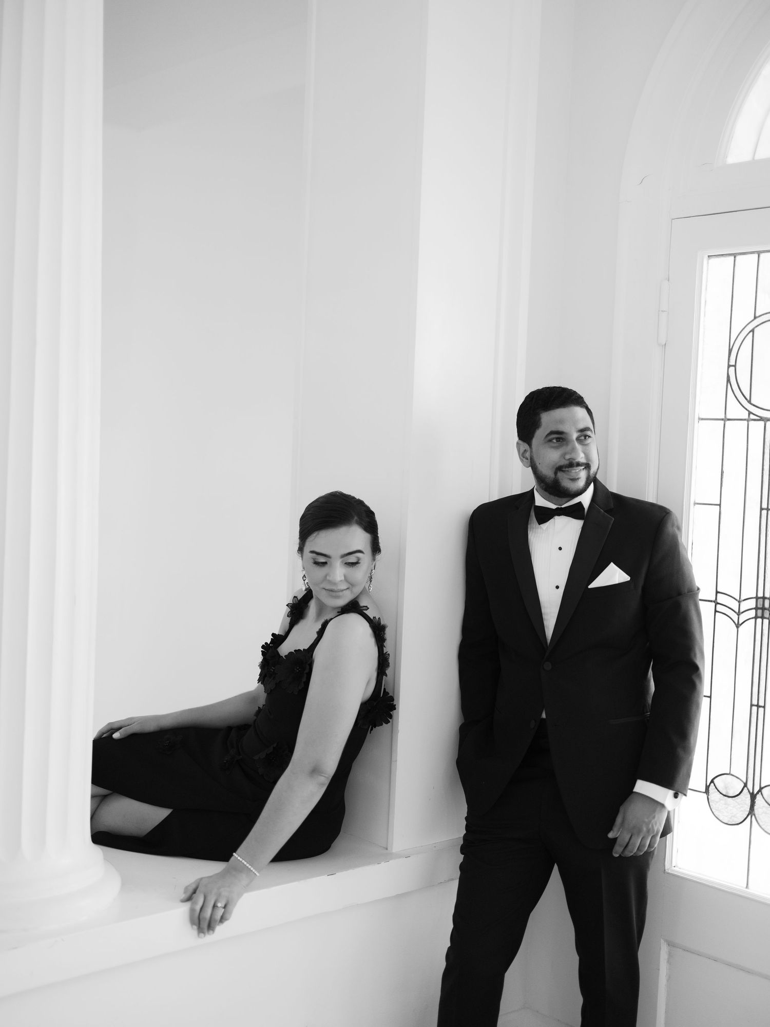 Black and white portraits in a bright white room with architectural columns.