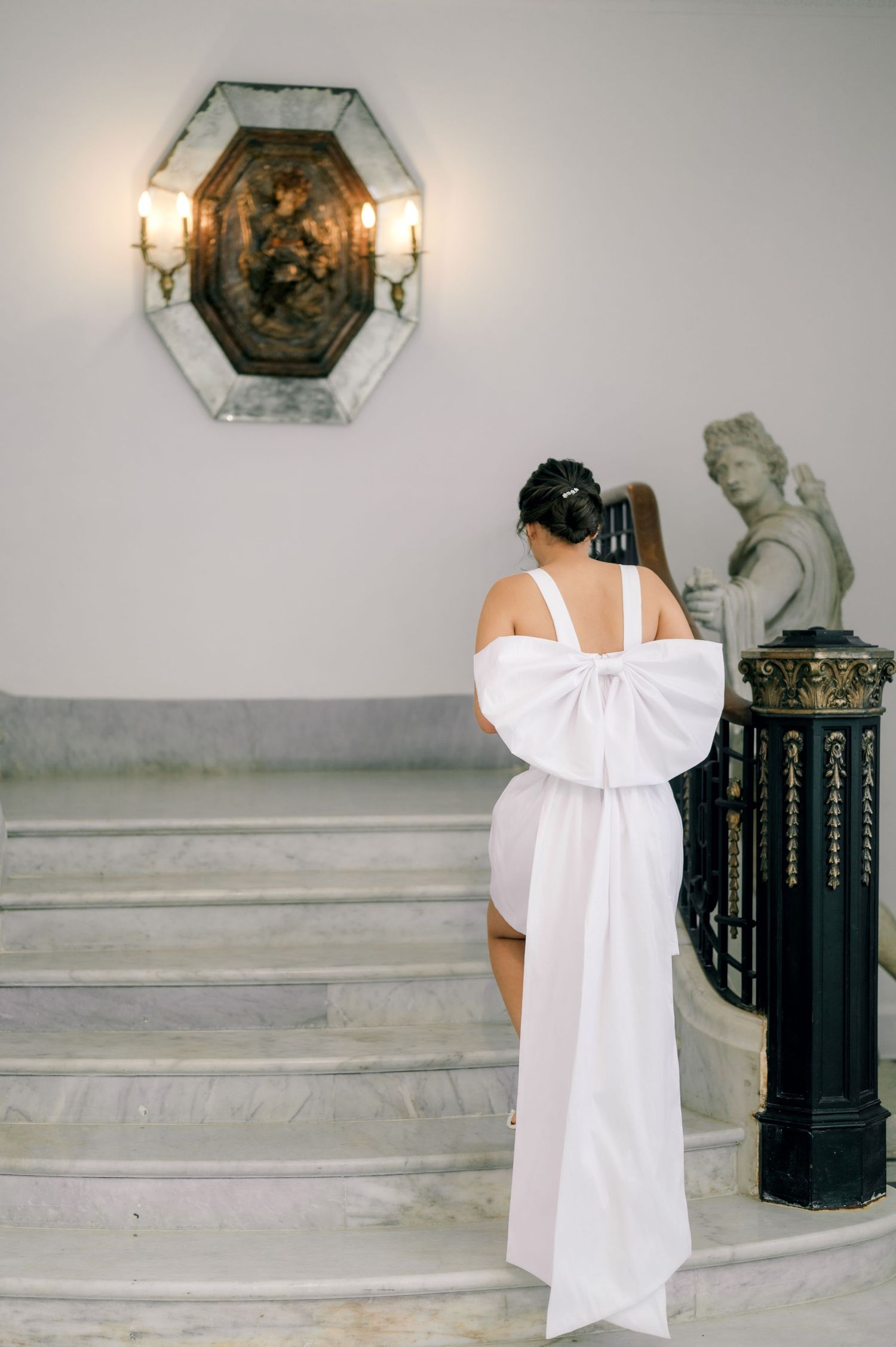 A series of connected white walls with classical architectural details and decorative elements in a gallery-like setting.